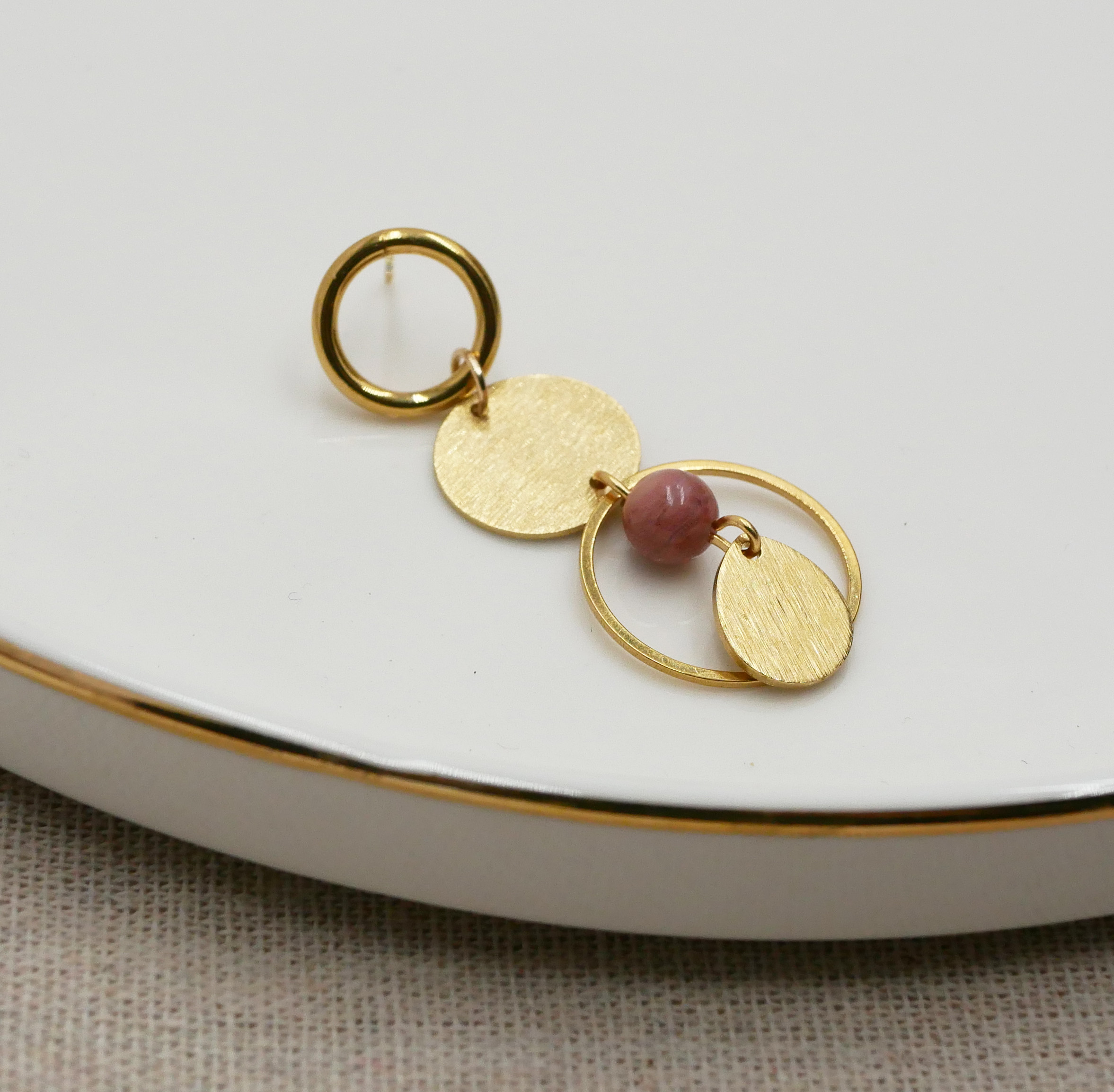 Soloörhänge med ringar och cirklar i guld och rosa rhodonitpärla