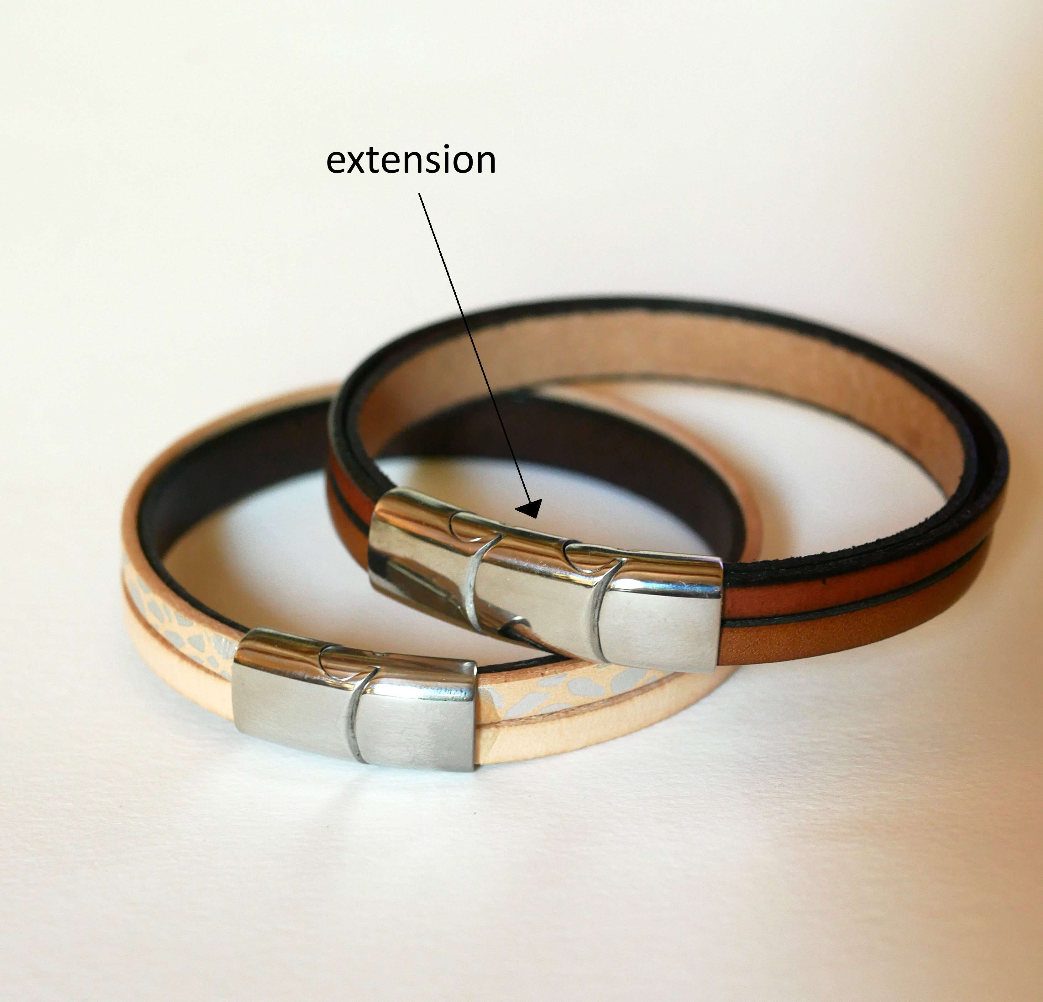 Armband i brunt l&auml;der med fl&auml;tat metallfoder och magnetl&aring;s