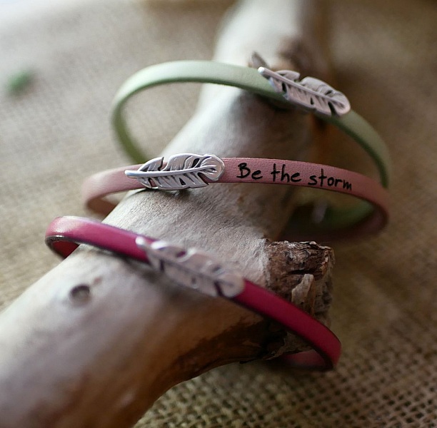 Flickarmband i l&auml;der med fj&auml;der som kan g&ouml;ras personligt genom gravyr 