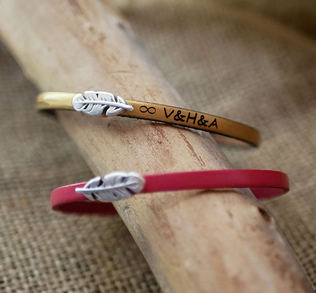 Flickarmband i l&auml;der med fj&auml;der som kan g&ouml;ras personligt genom gravyr 