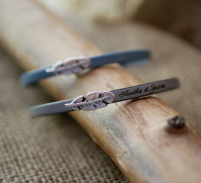 Flickarmband i l&auml;der med fj&auml;der som kan g&ouml;ras personligt genom gravyr 