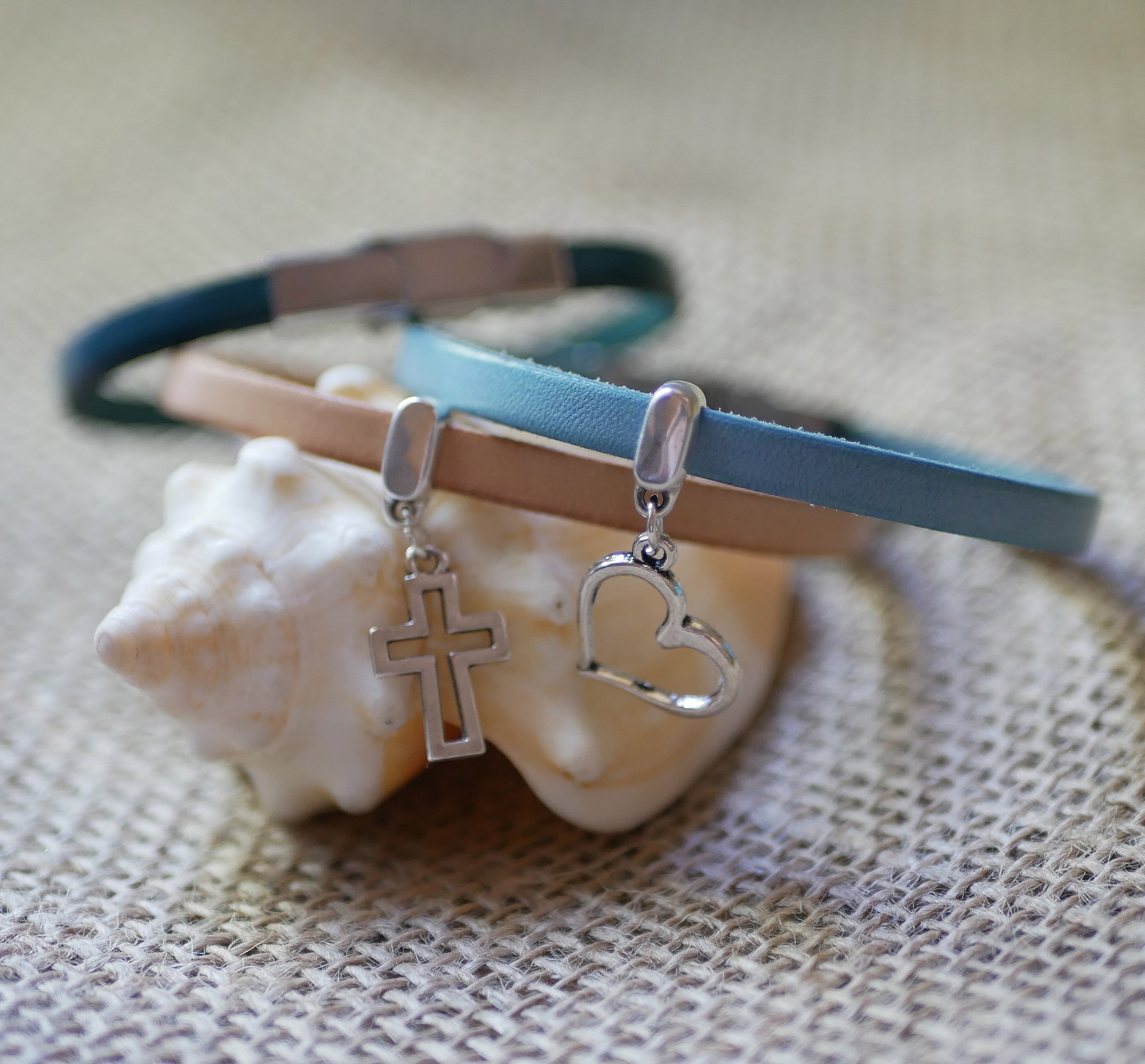 Bracelets en cuir personnalisables avec pendentifs argentés sur coquillage.