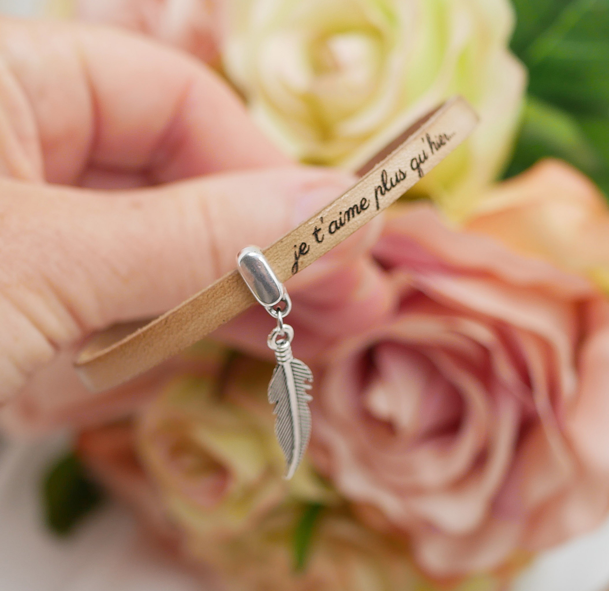 Bracelet en cuir personnalisé avec pendentif plume argenté.
