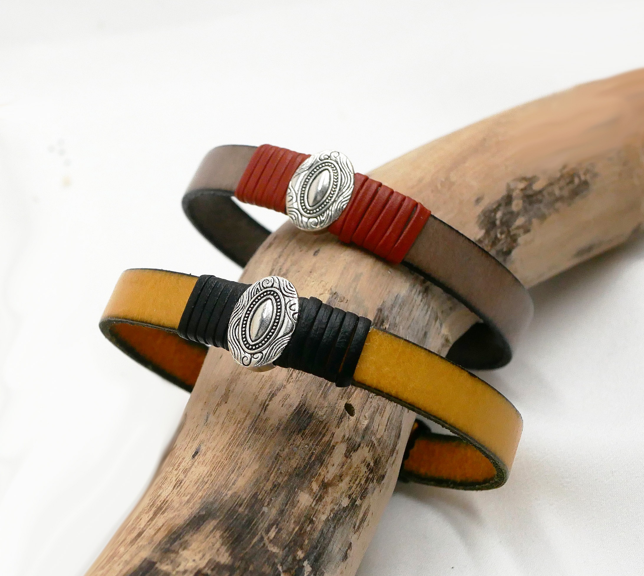 Anpassningsbar l&auml;derrem med centralt ovalt ornament inramat av fina l&auml;derdetaljer 