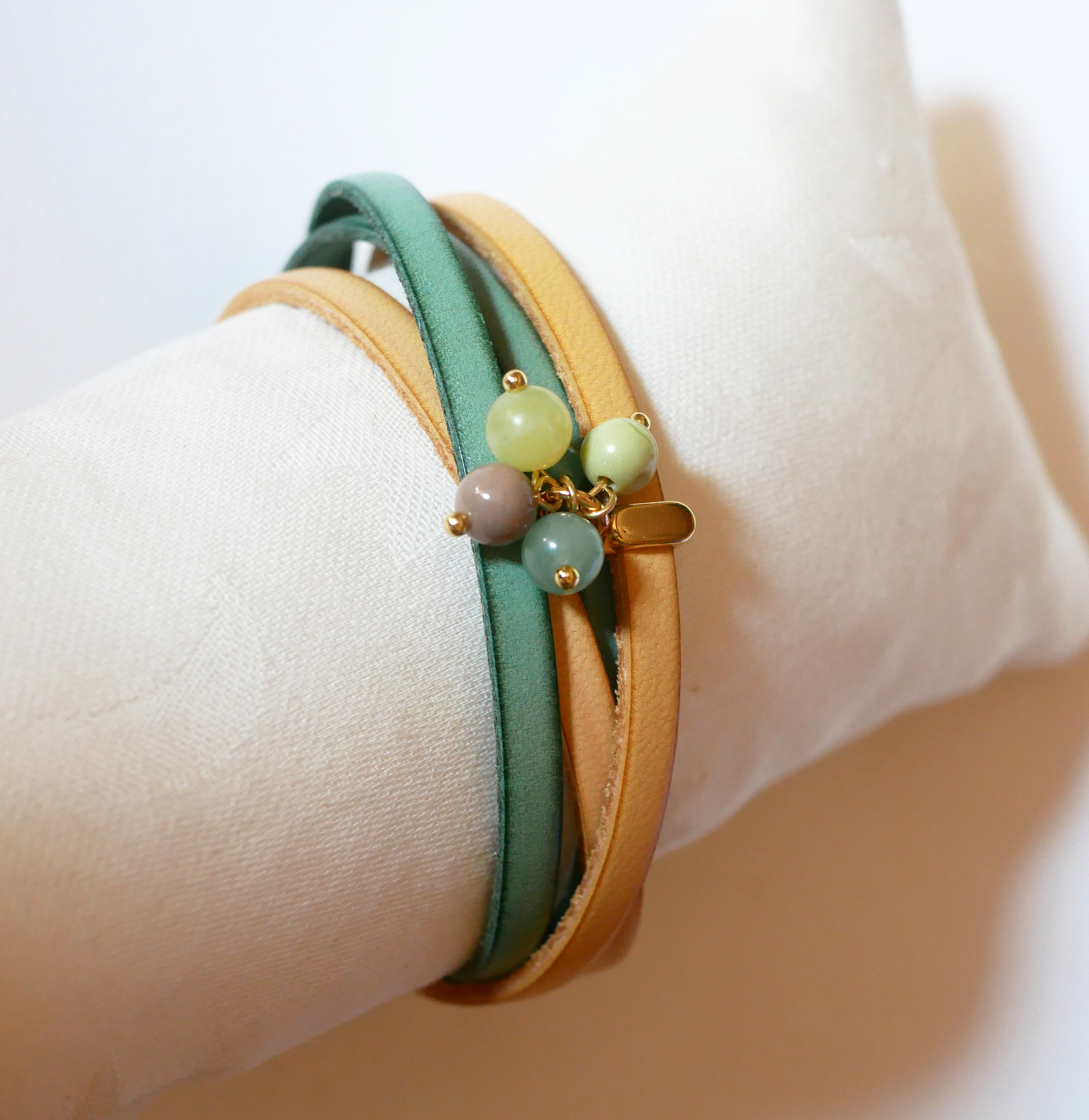Dubbelt läderarmband dekorerat med mjuka gröna pärlor och guldspänne