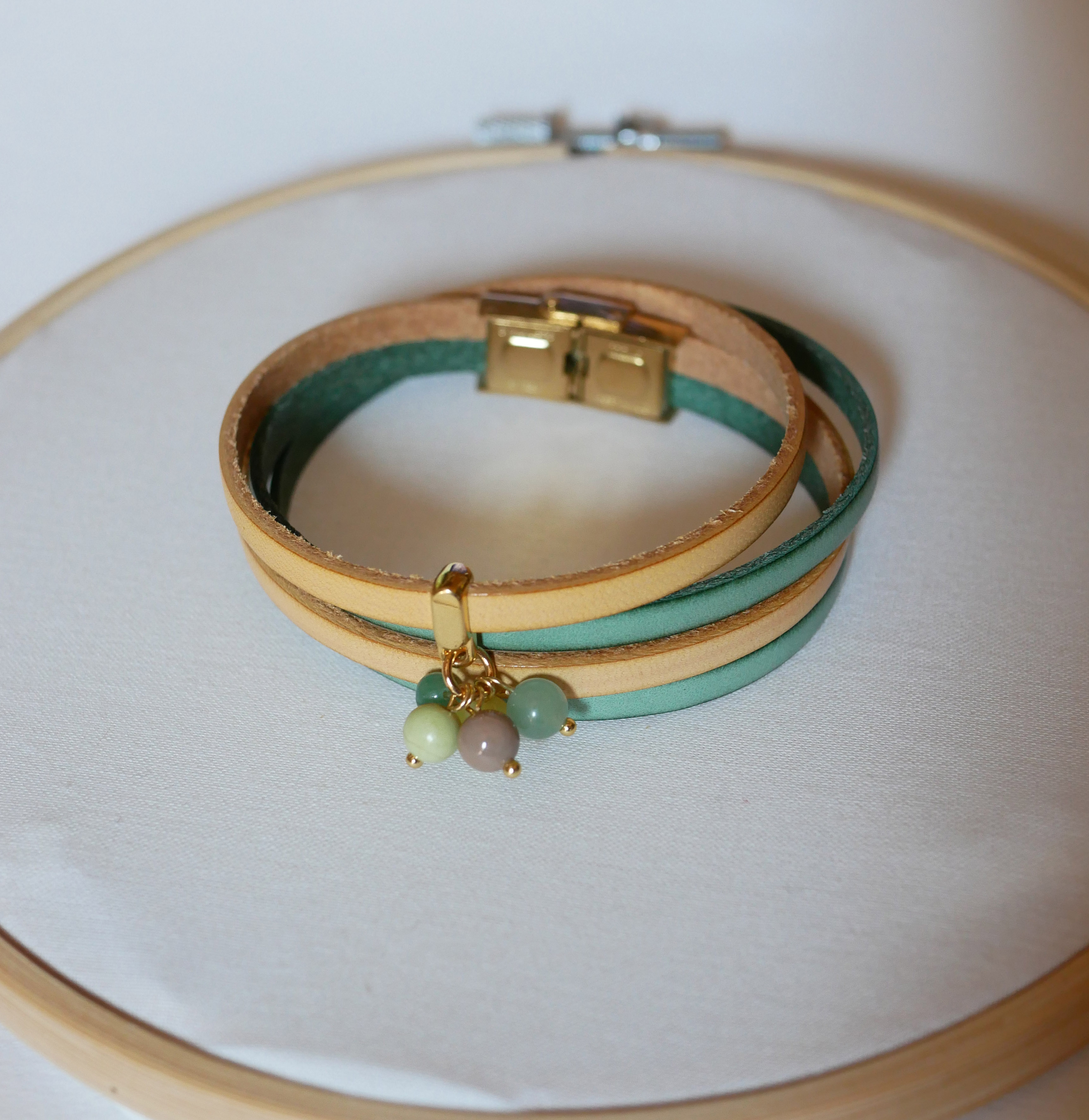 Dubbelt läderarmband dekorerat med mjuka gröna pärlor och guldspänne