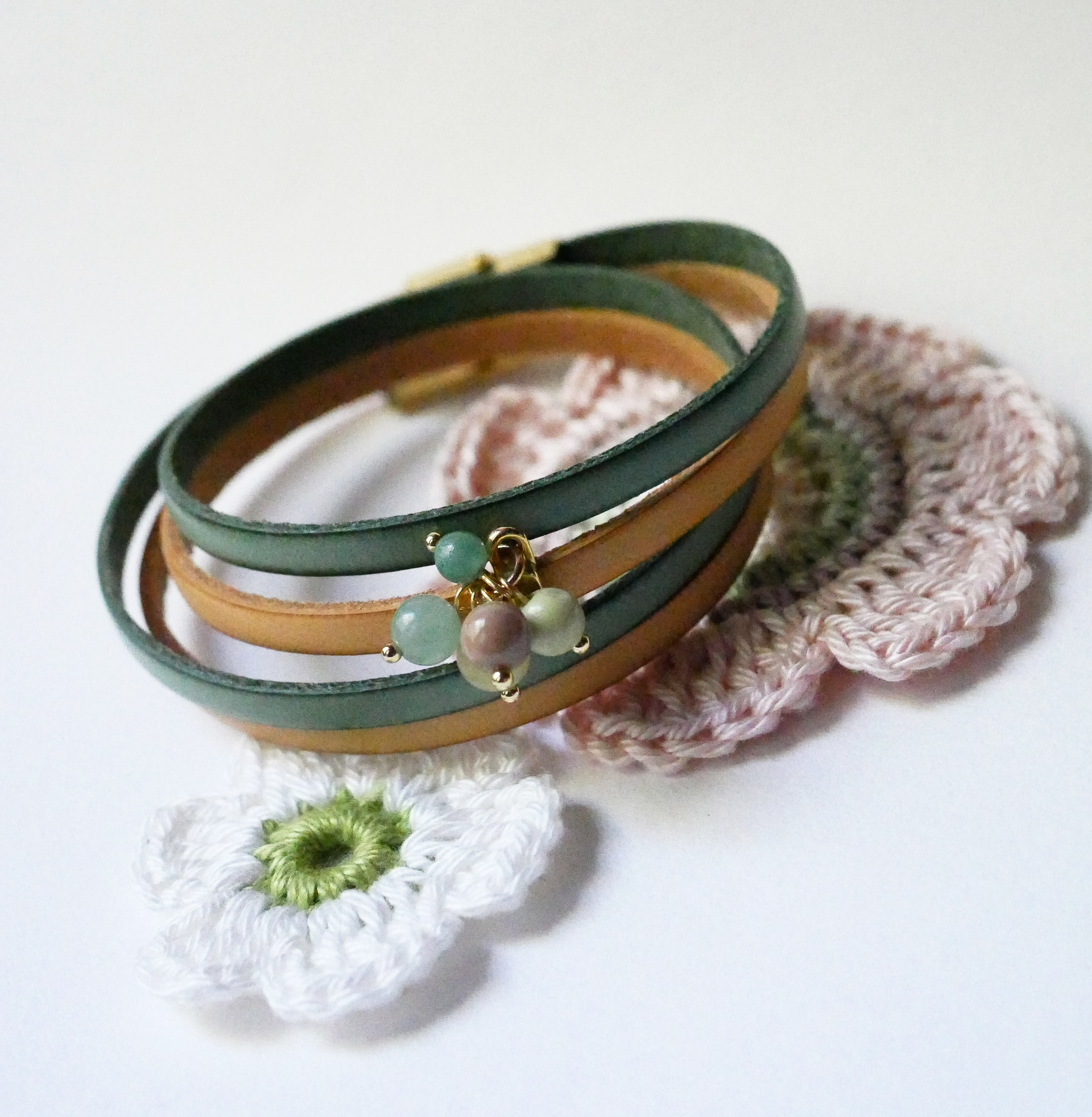 Dubbelt läderarmband dekorerat med mjuka gröna pärlor och guldspänne