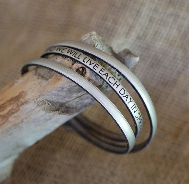 Bracelet personnalisé en métal gravé sur un bois flotté.