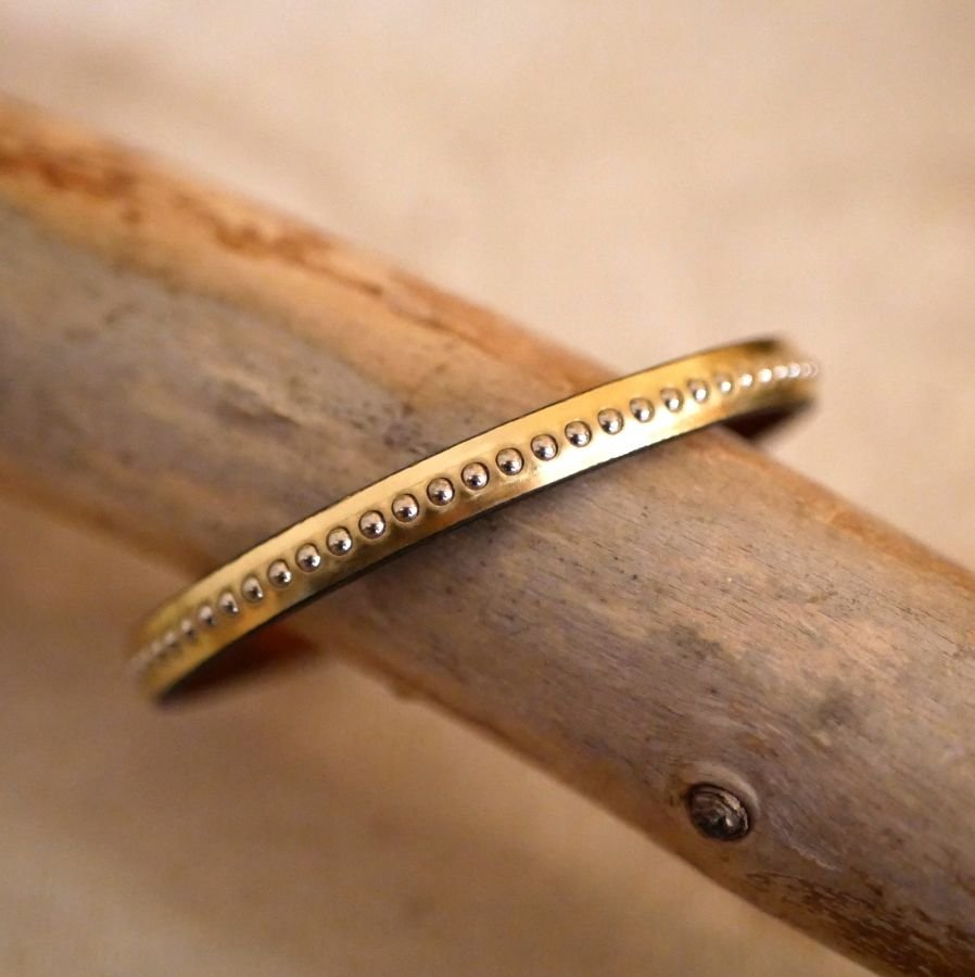 Kvinnoarmband i rosa metalliskt läder med guldpärlor