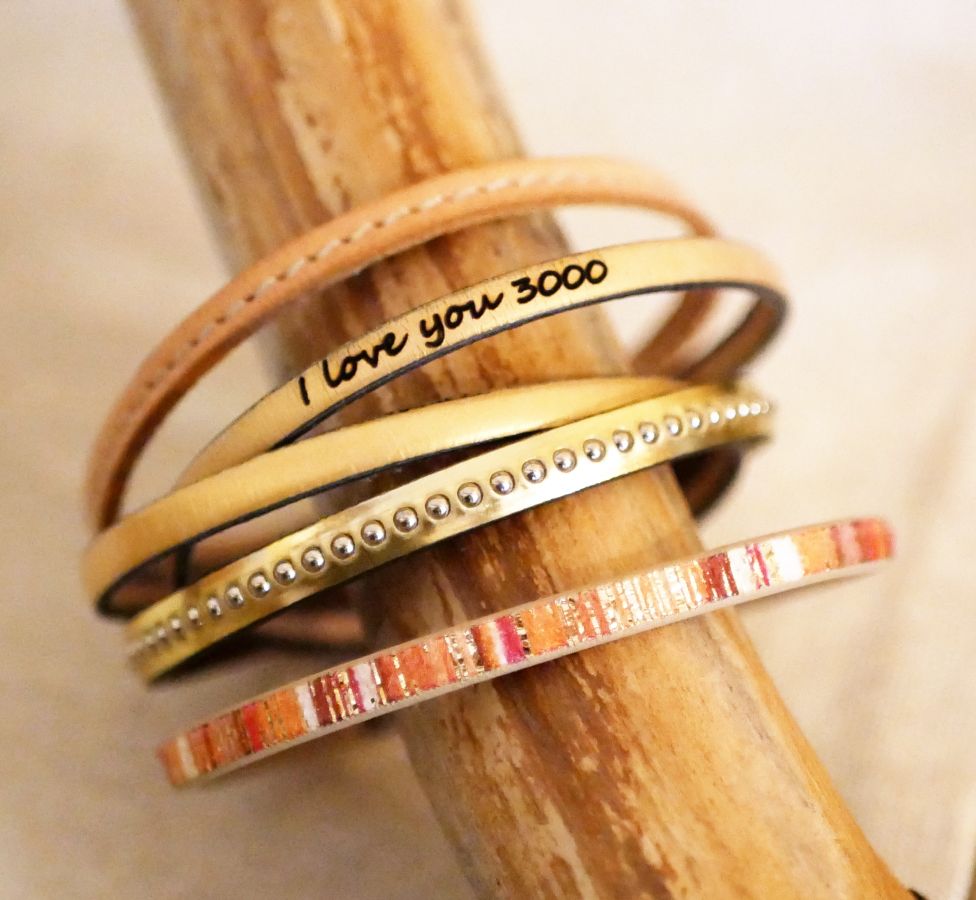 Kvinnoarmband i rosa metalliskt läder med guldpärlor