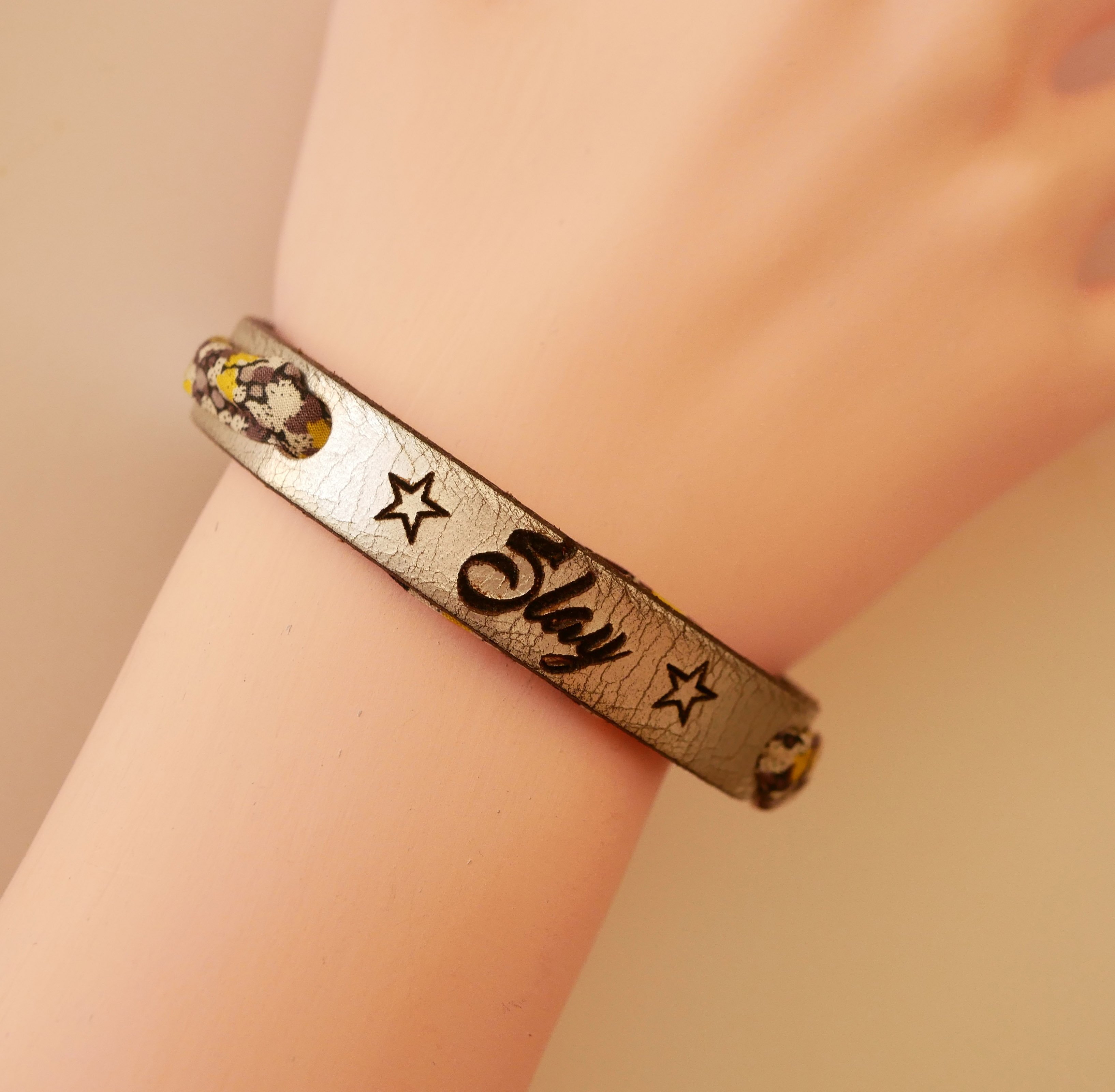 Florâme-armband graverat med gula blommor i libertyband på silverläder