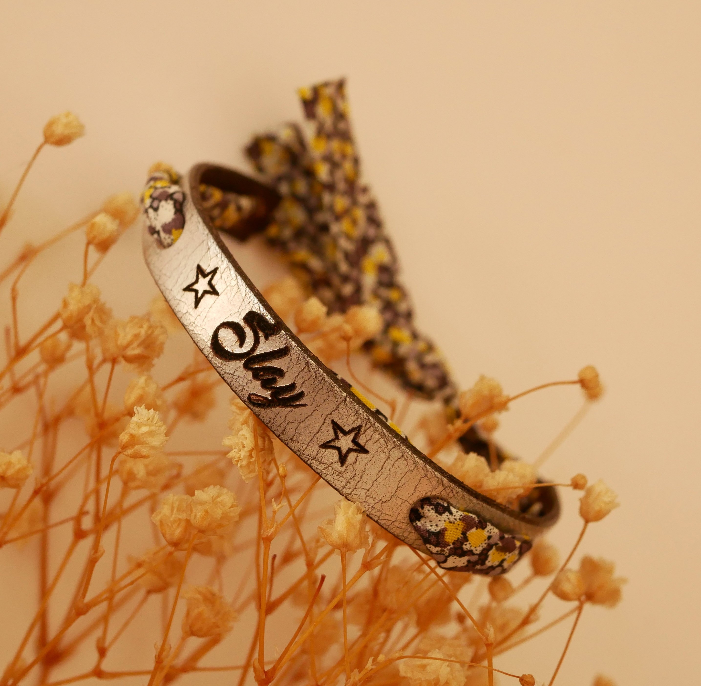 Florâme-armband graverat med gula blommor i libertyband på silverläder