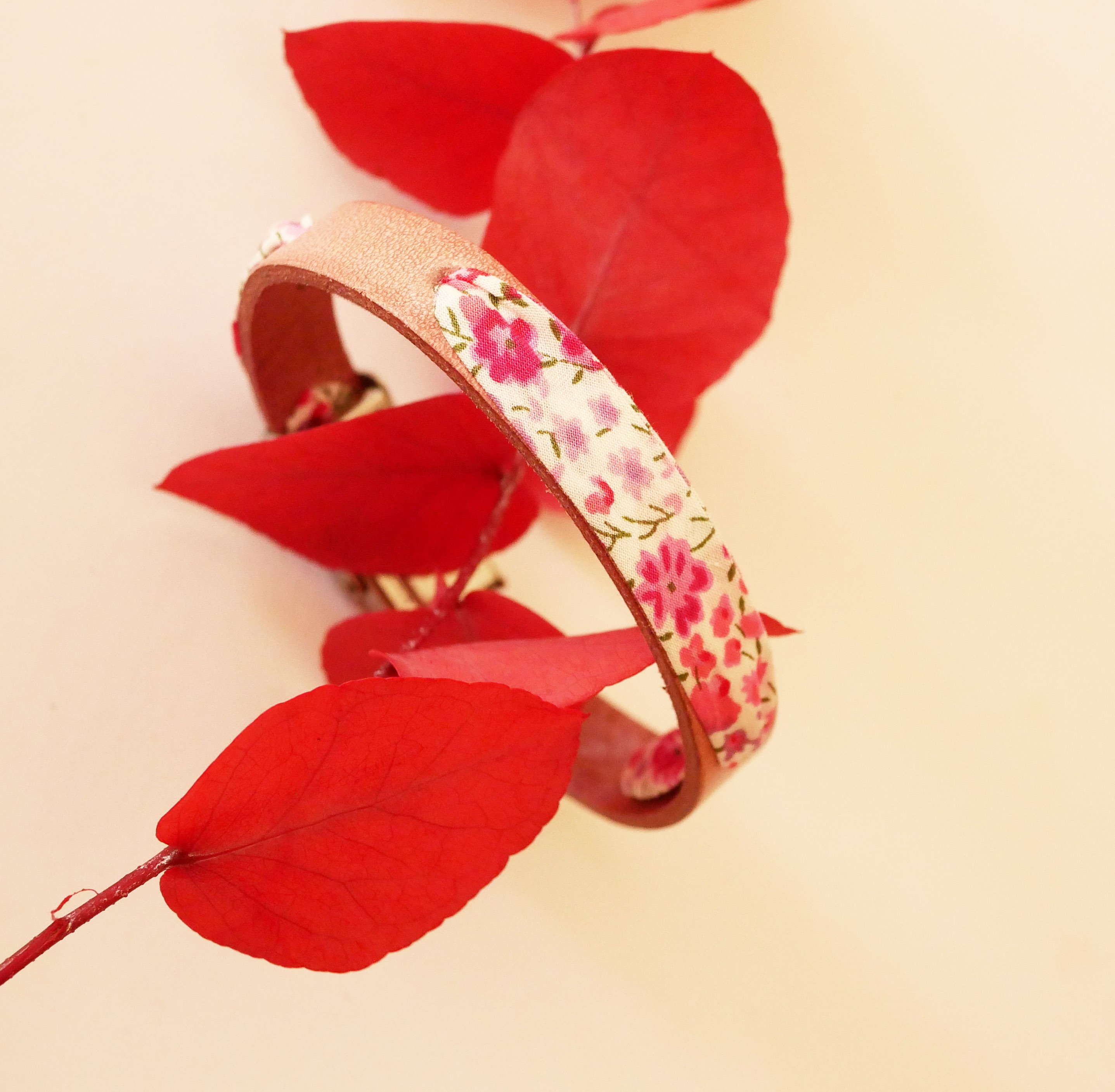 Florâme-armband med rosa blommor i libertyband på åldrat rosa läder