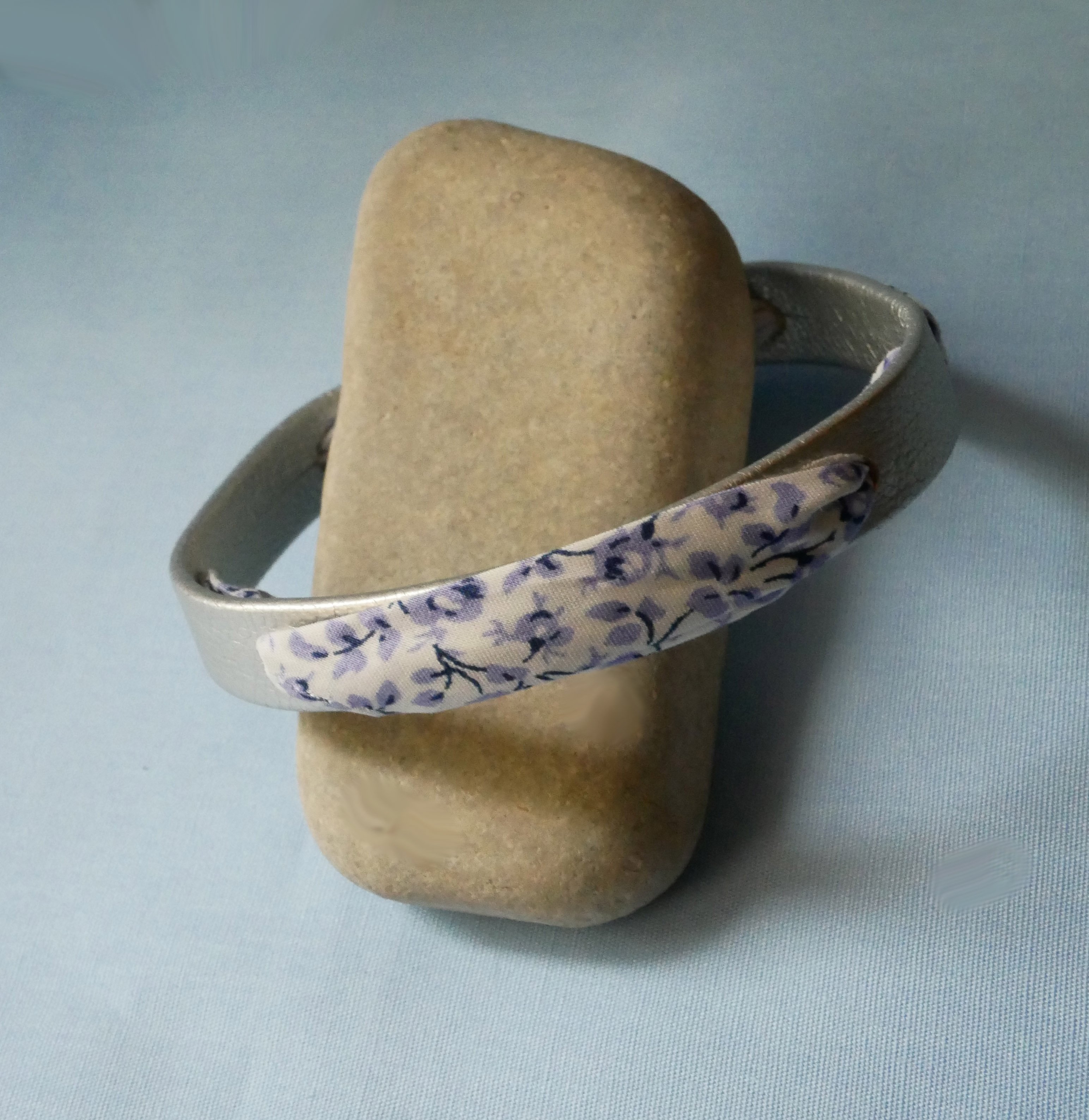 Florâme-armband med blå blommor i libertyband på silverläder