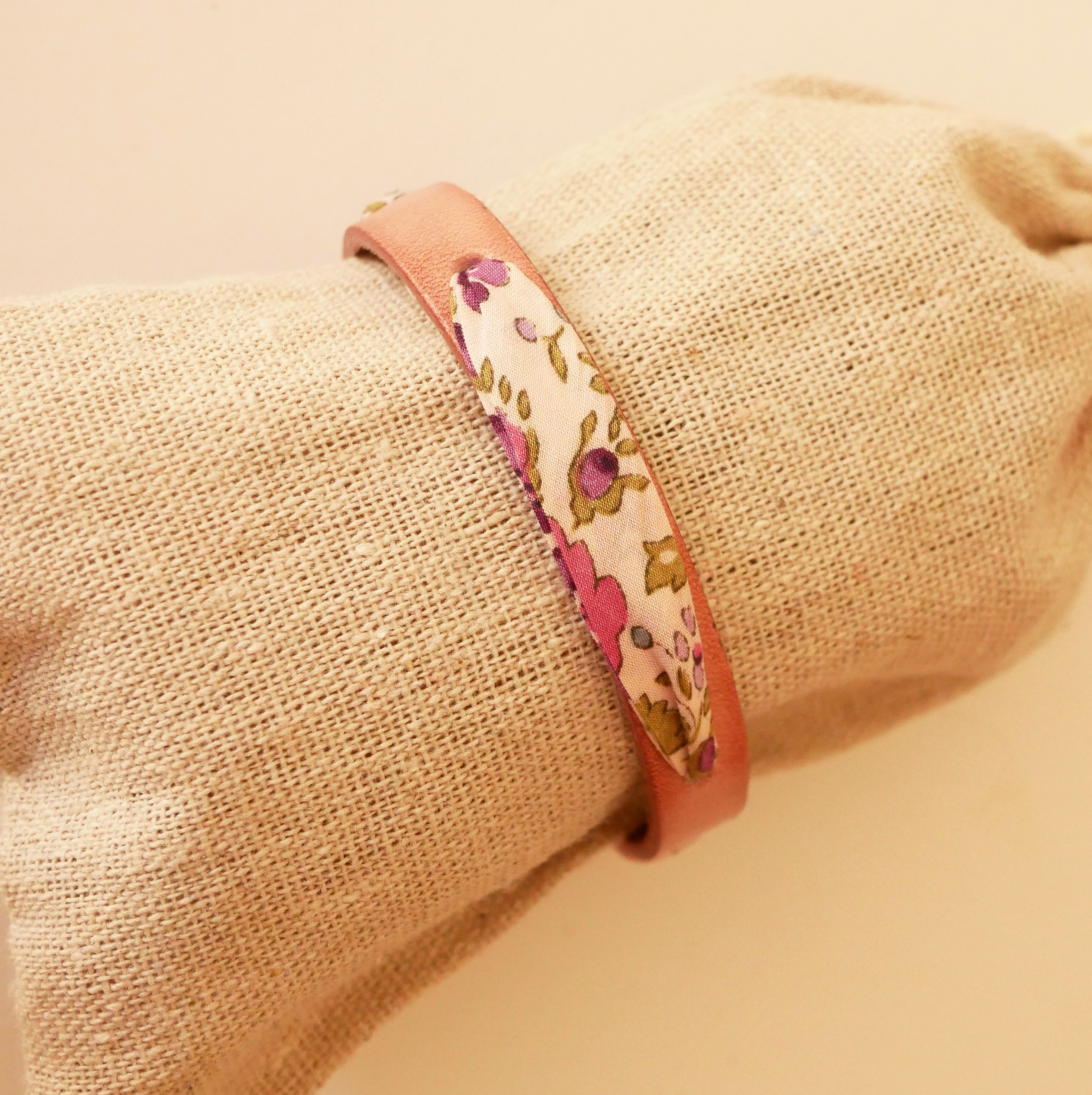 Florâme-armband med libertyband och lila blommor på åldrat rosa läder