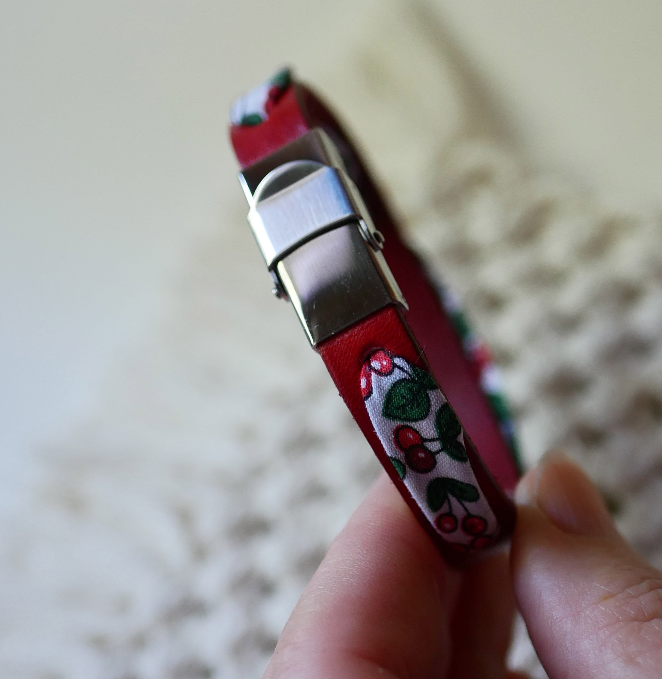Florâme-armband med band av körsbärsfrukt på rött läder