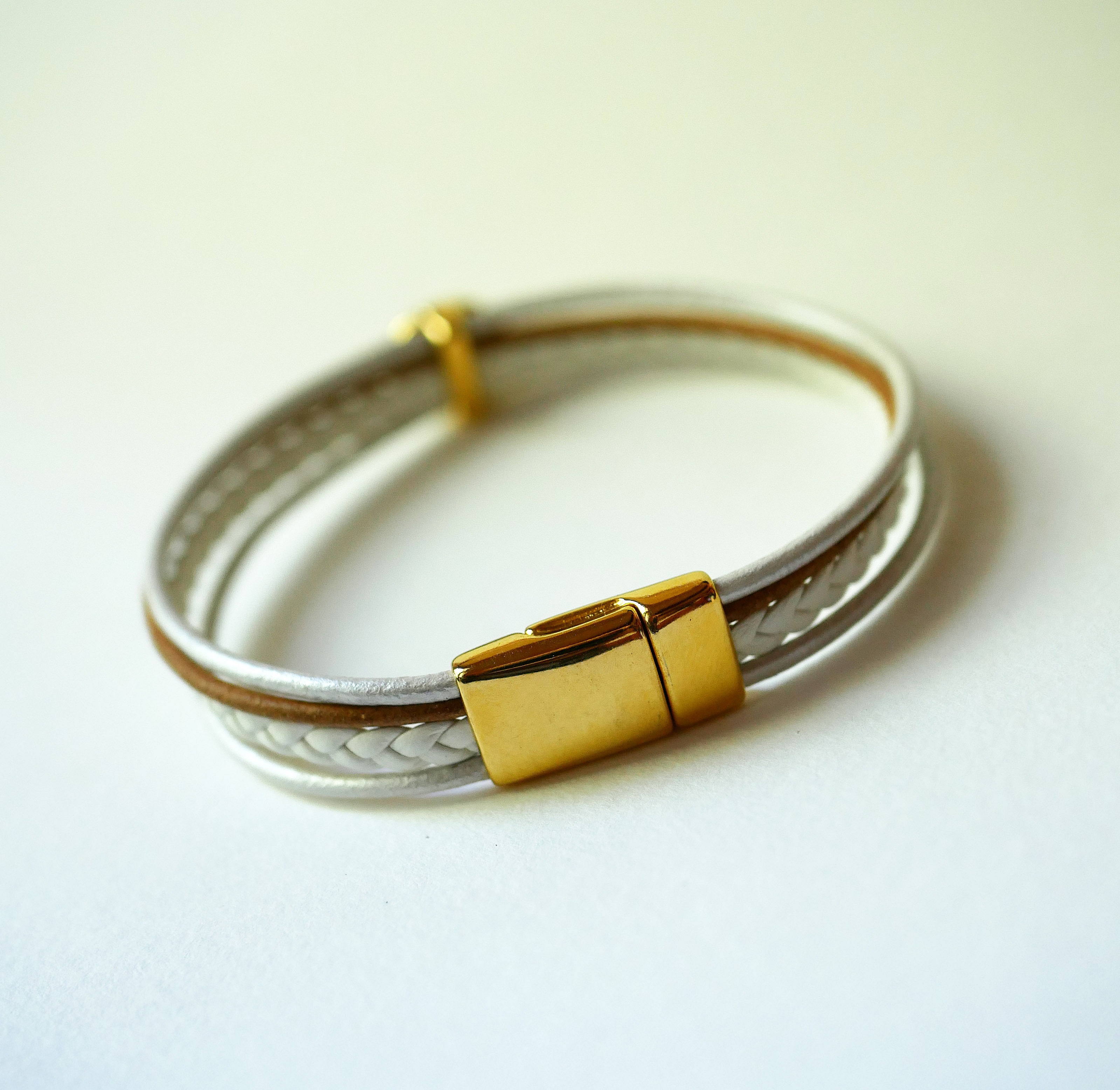 Bracelet manchette multi-cordons en cuir blanc et fermoir doré.