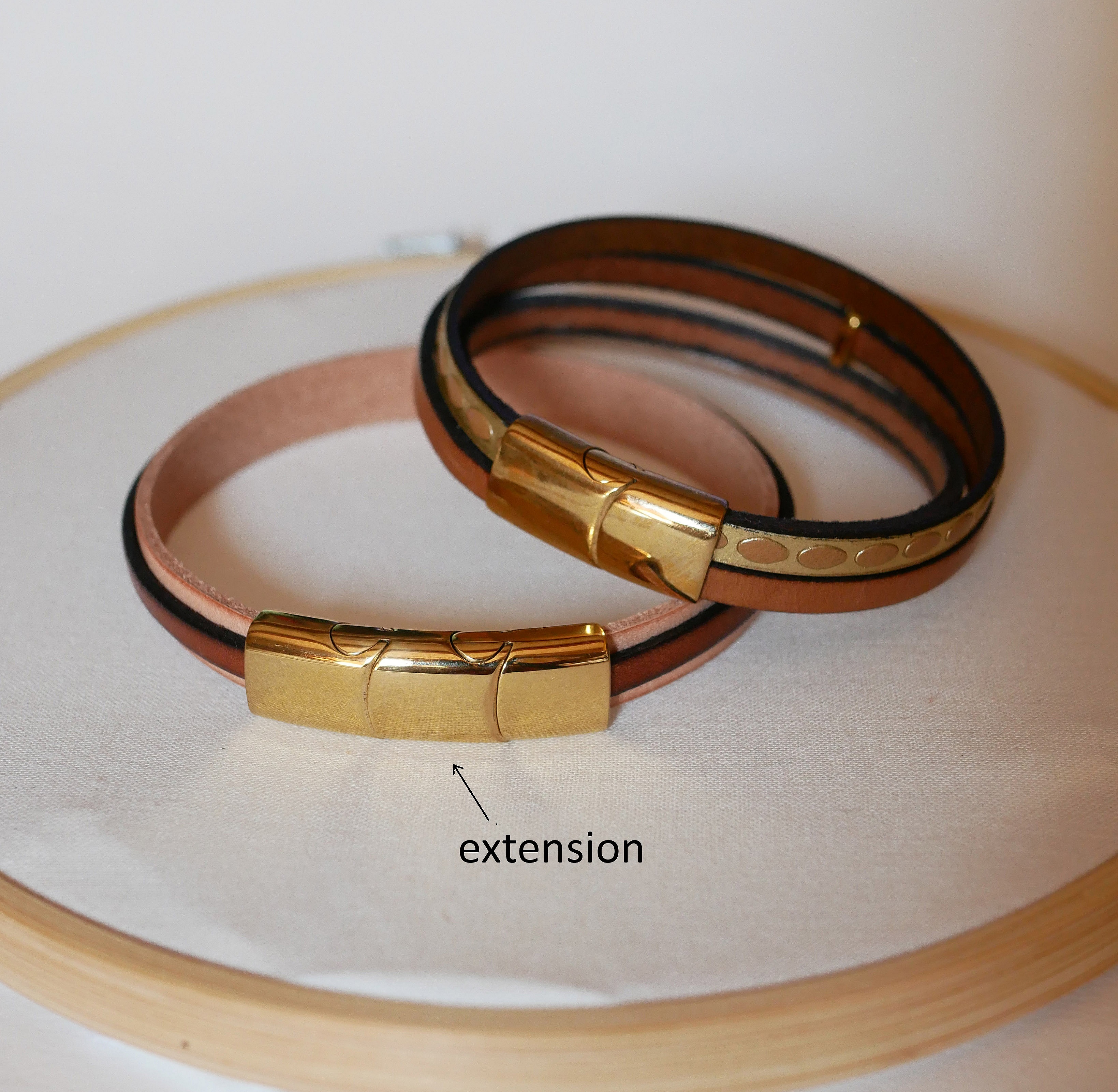 Manschettarmband i l&auml;der med flera l&auml;nkar och solstr&aring;le&ouml;gla i guld