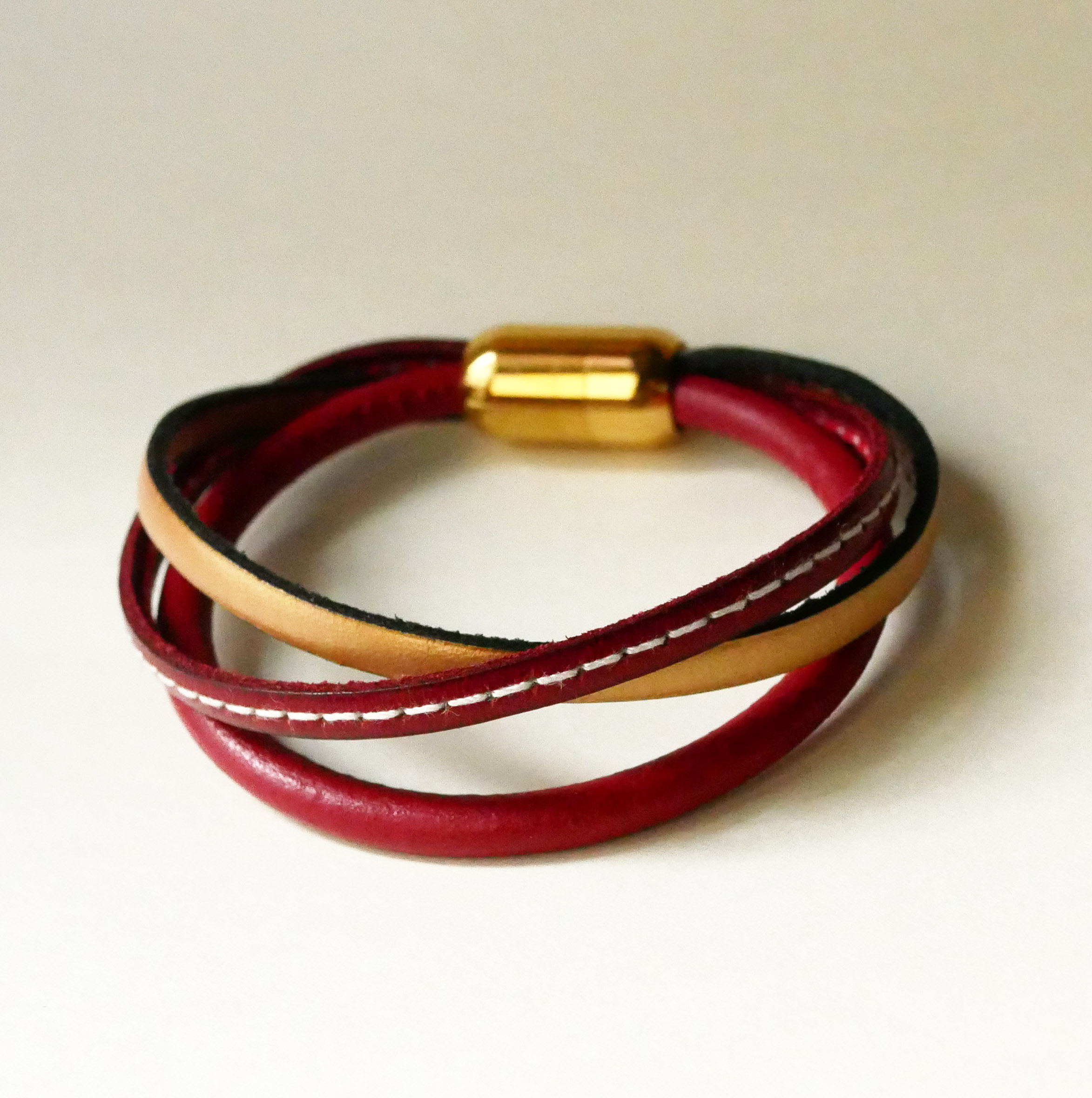 Manschettarmband för kvinnor i rött och guld med flera läderdetaljer