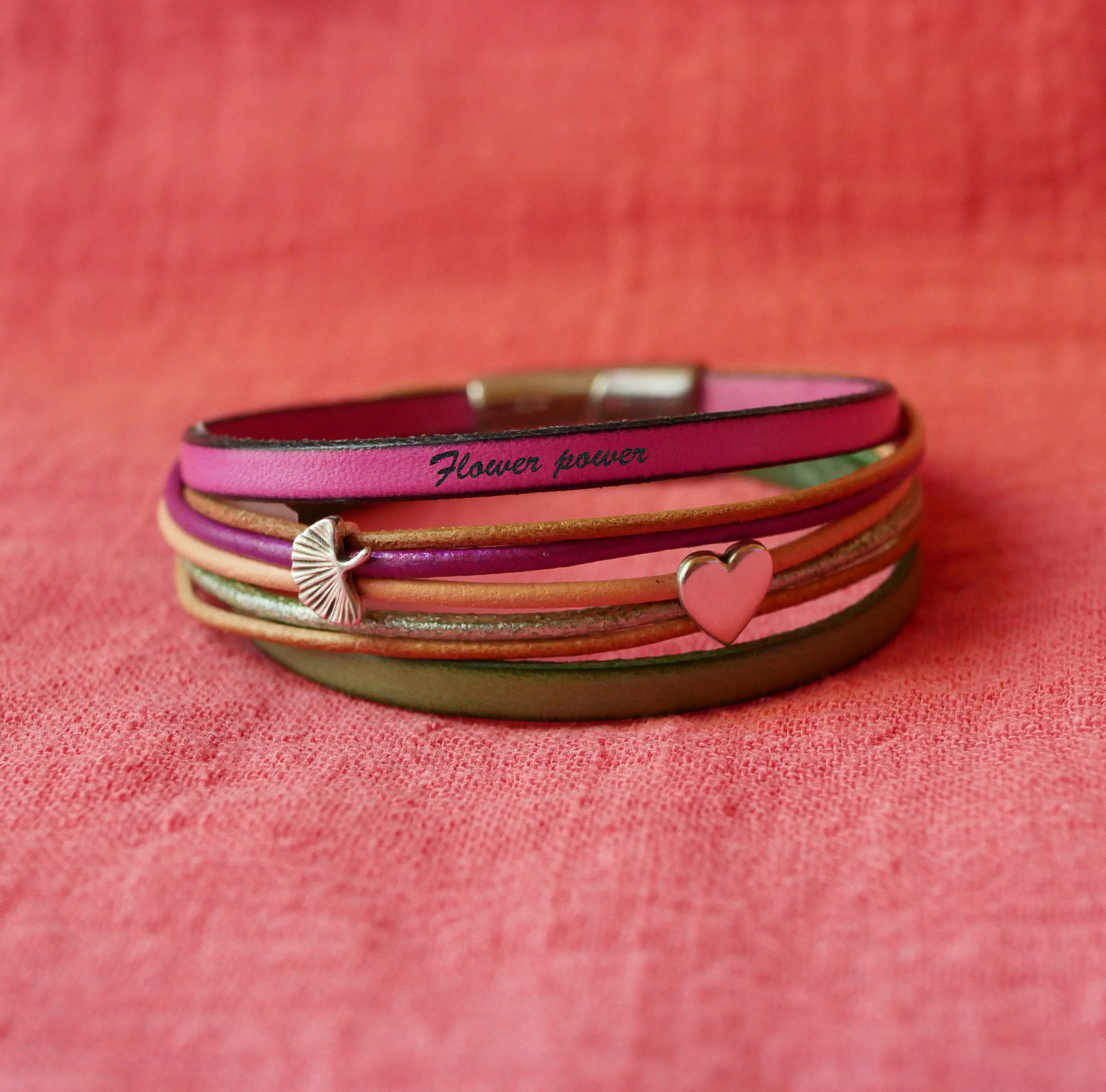 Manschettarmband i fuchsialäder med 2 silverfärgade öglor