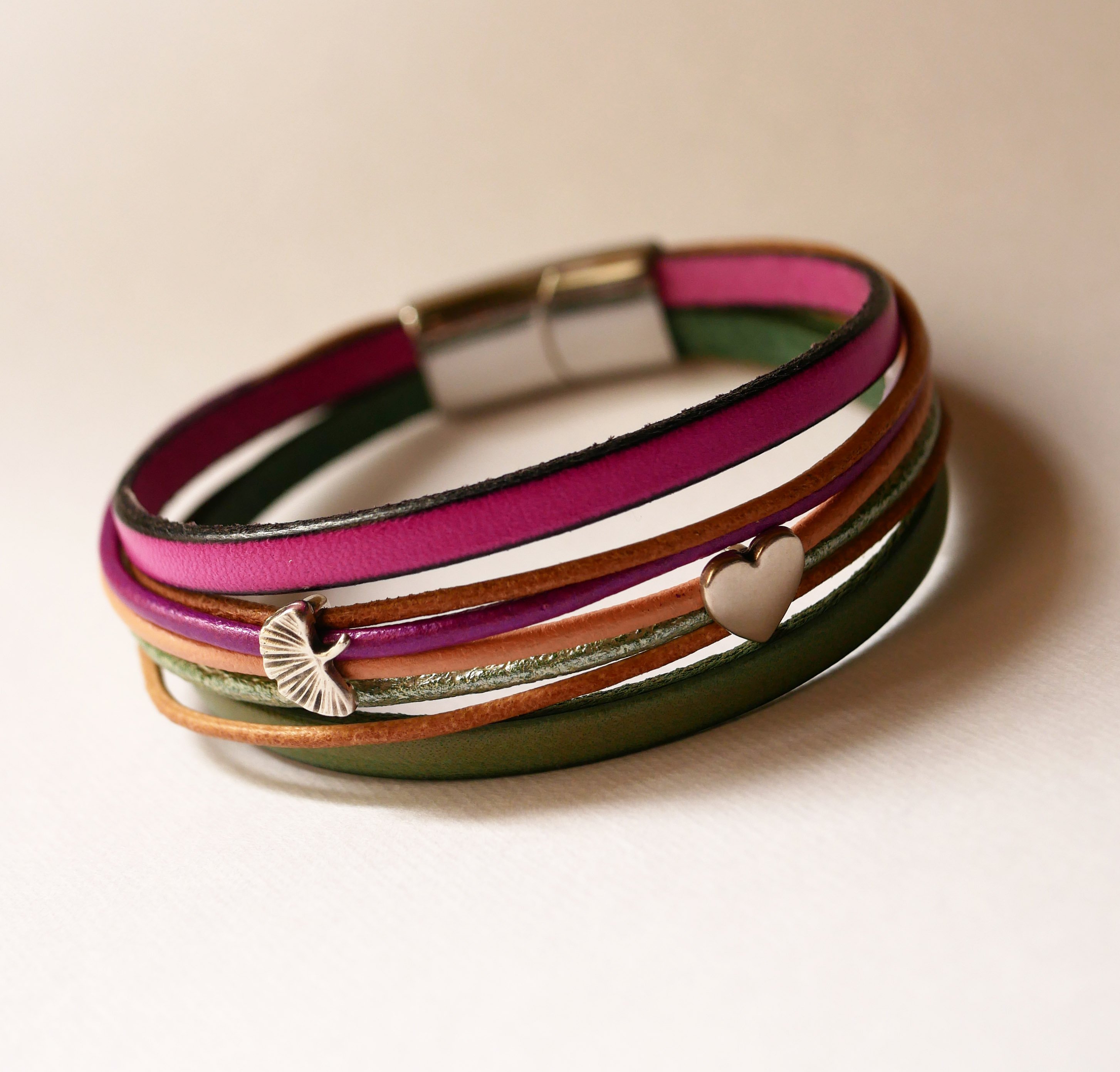 Manschettarmband i fuchsialäder med 2 silverfärgade öglor