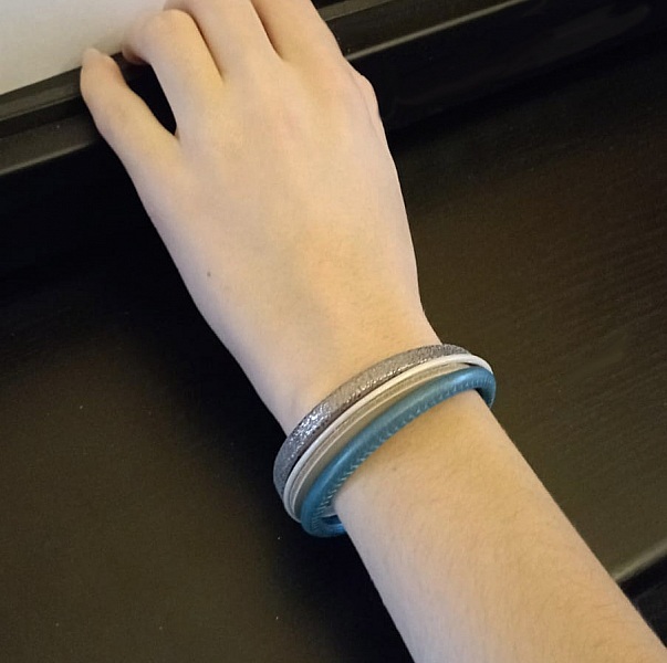 Manschettarmband i bl&aring;tt och silver med flera l&auml;derdetaljer