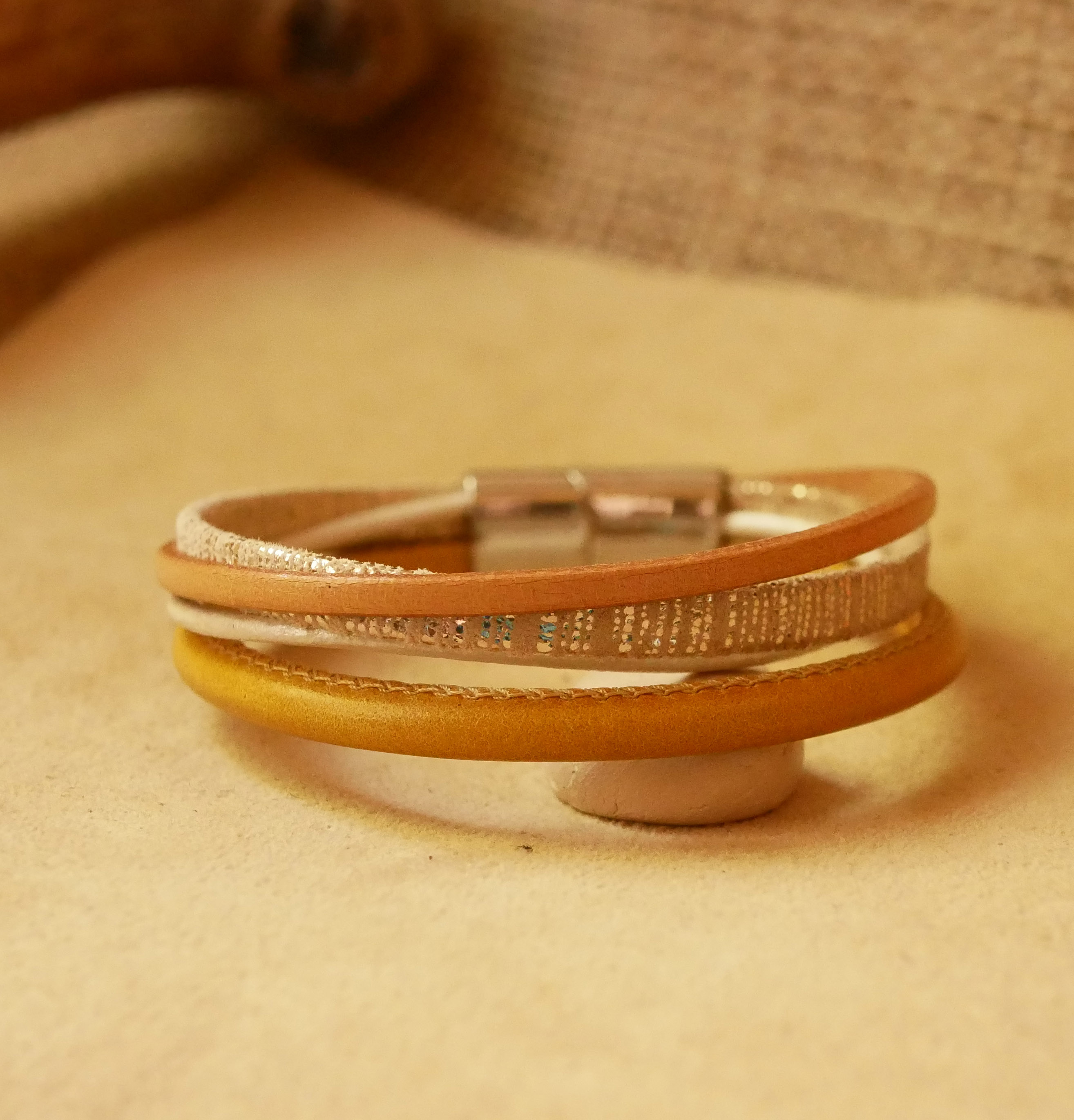Manschettarmband i beige och guld med flera läderdetaljer