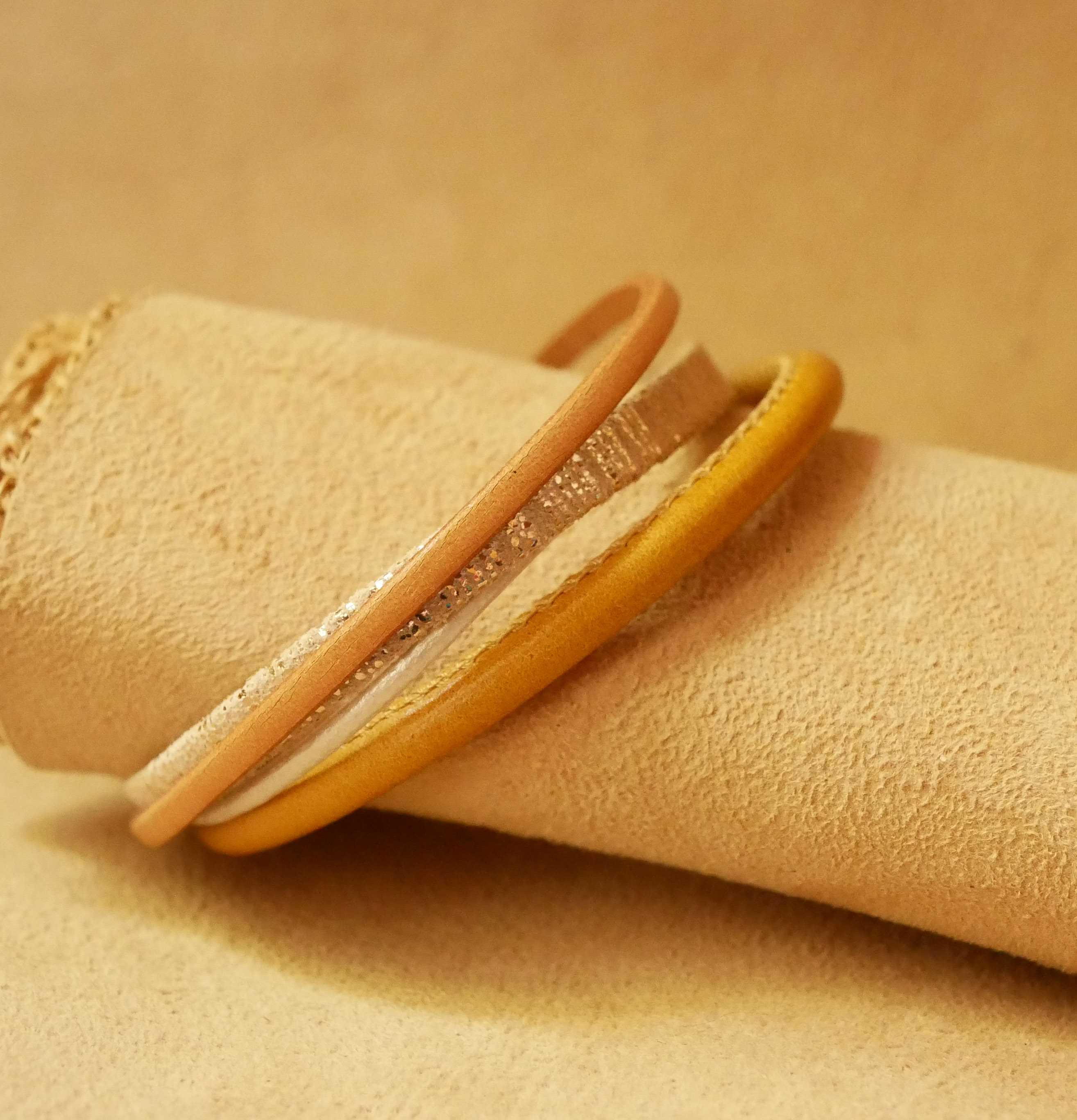 Manschettarmband i beige och guld med flera läderdetaljer