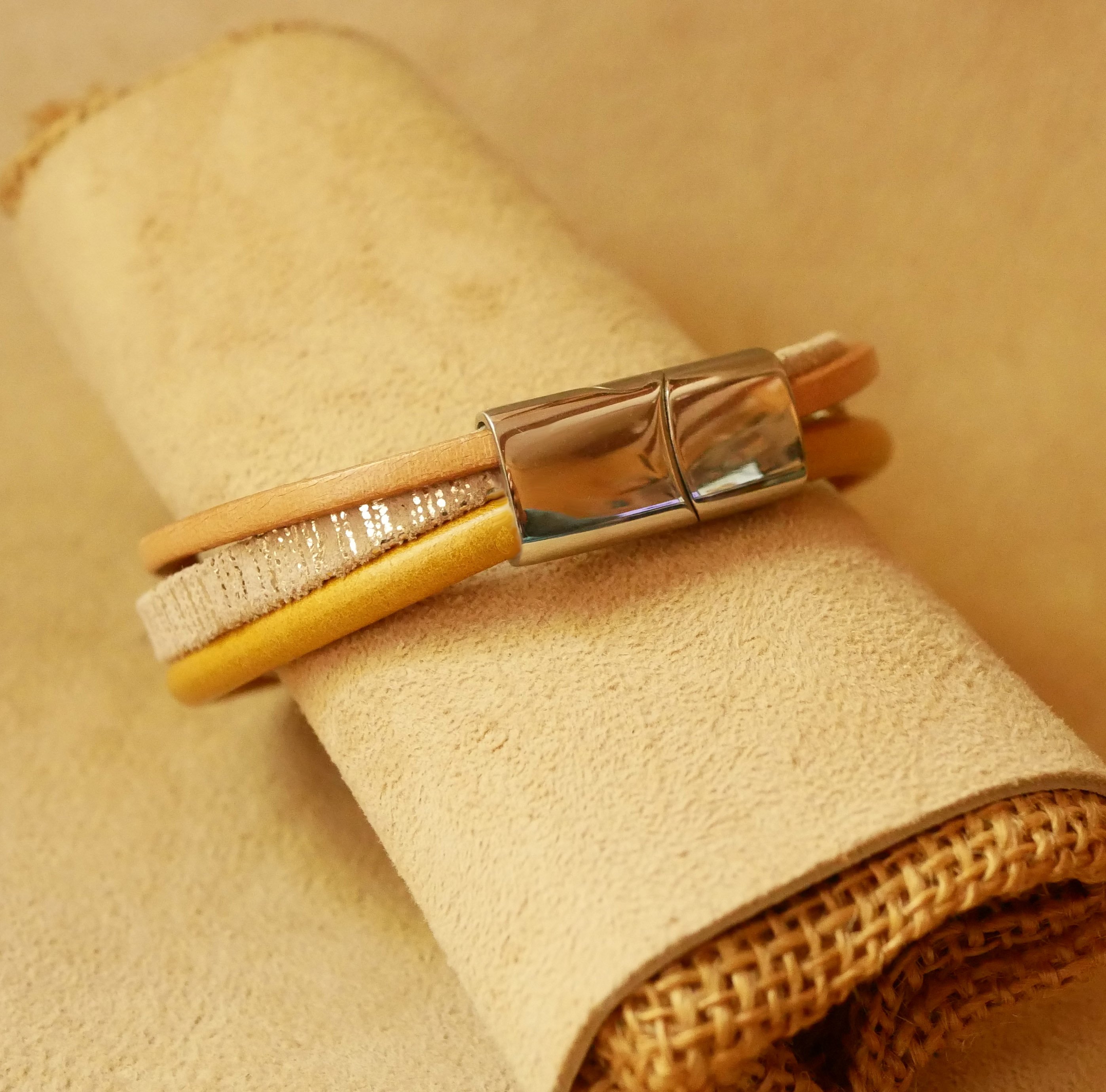 Manschettarmband i beige och guld med flera läderdetaljer
