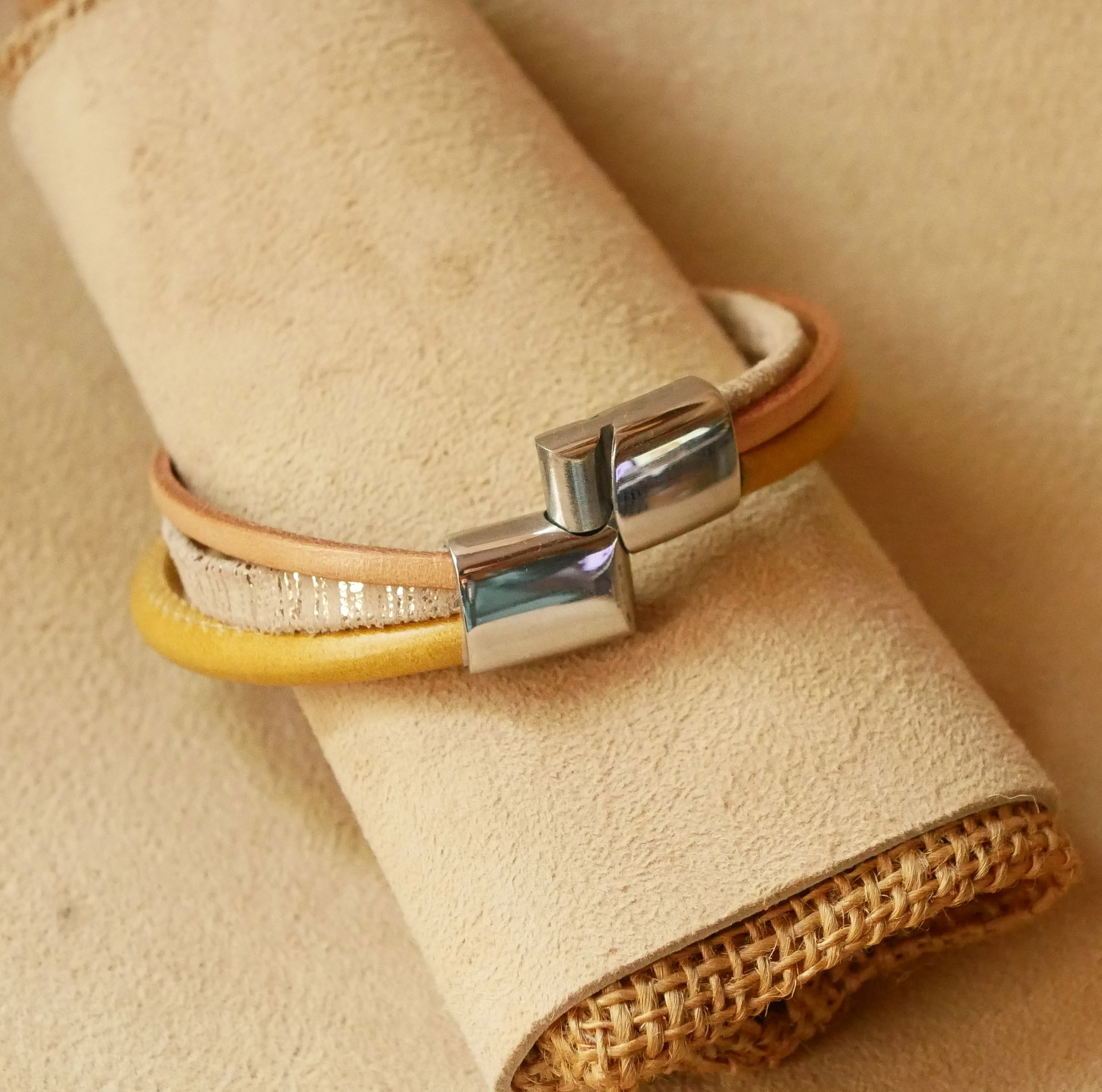 Manschettarmband i beige och guld med flera läderdetaljer