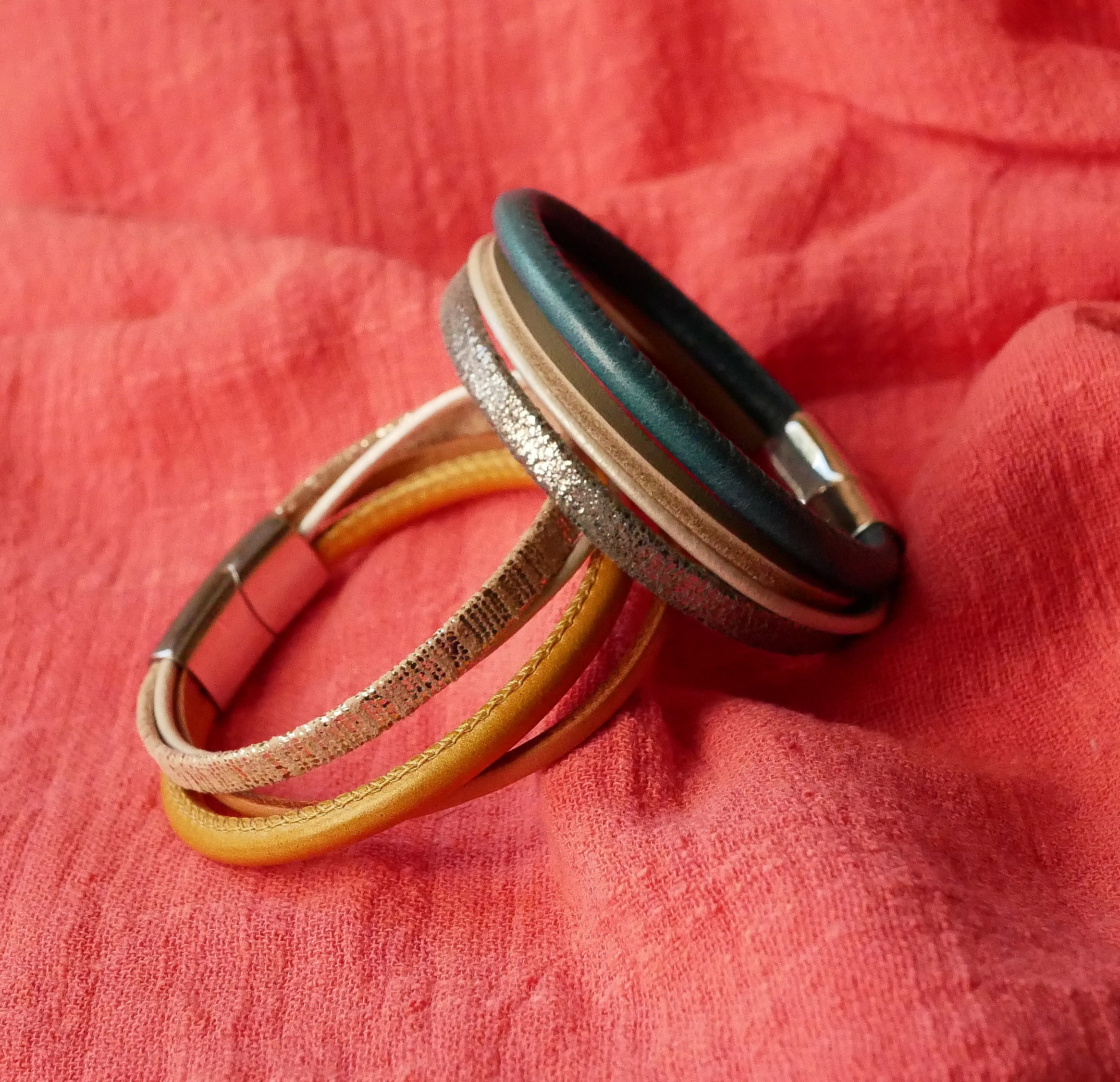 Manschettarmband i beige och guld med flera l&auml;derdetaljer