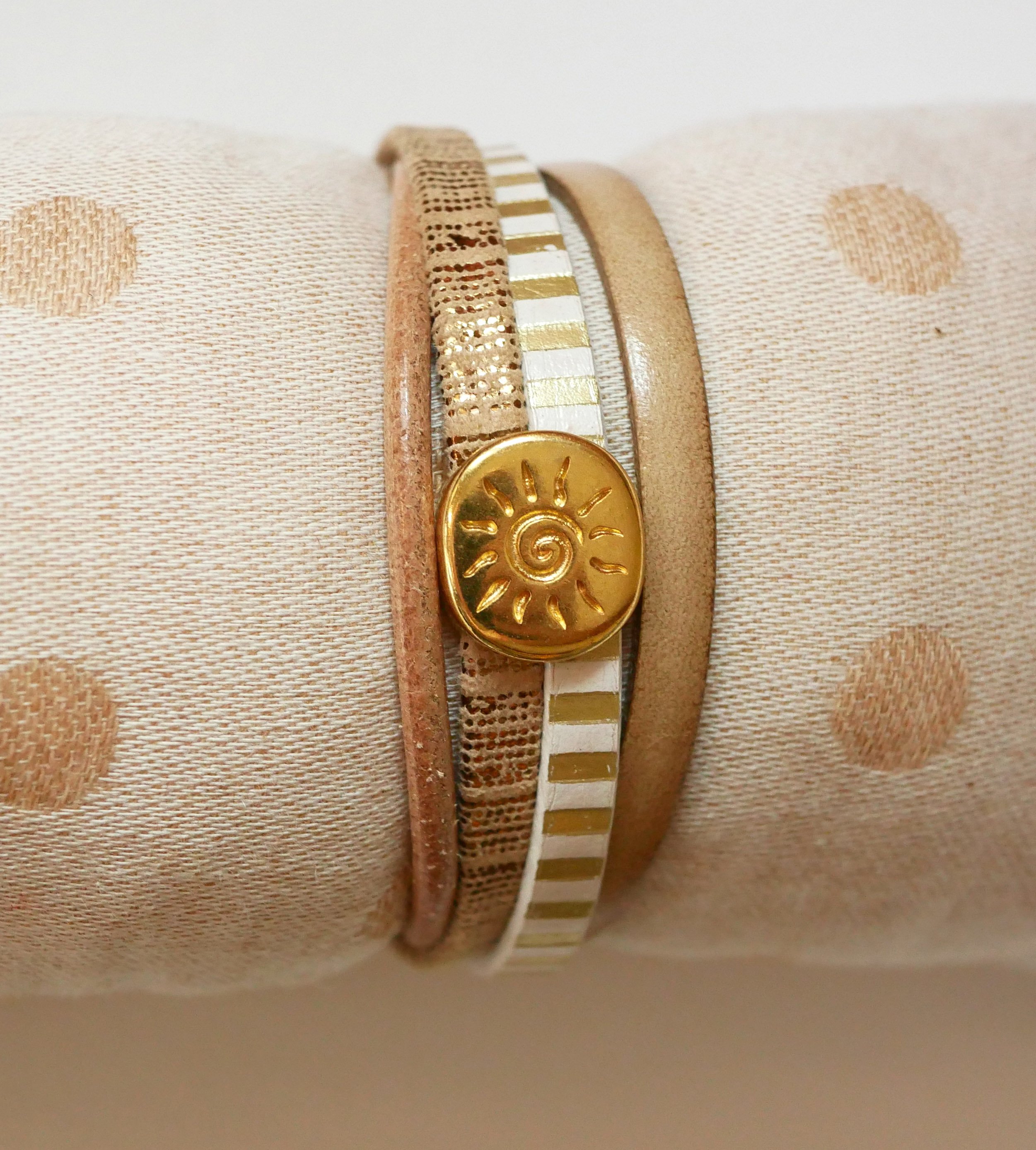 Manschettarmband i läder med flera länkar och solstråleögla i guld