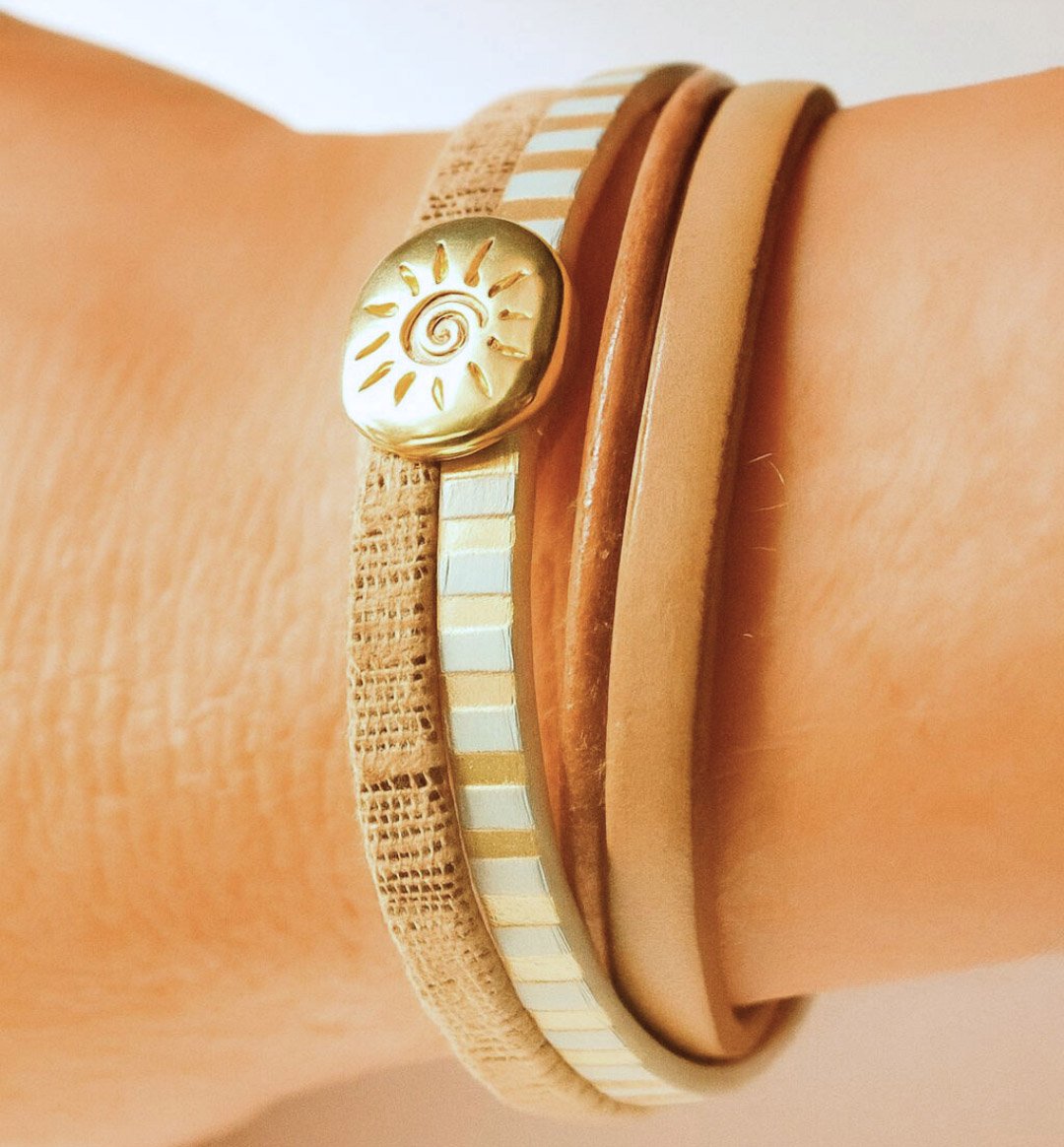 Manschettarmband i läder med flera länkar och solstråleögla i guld
