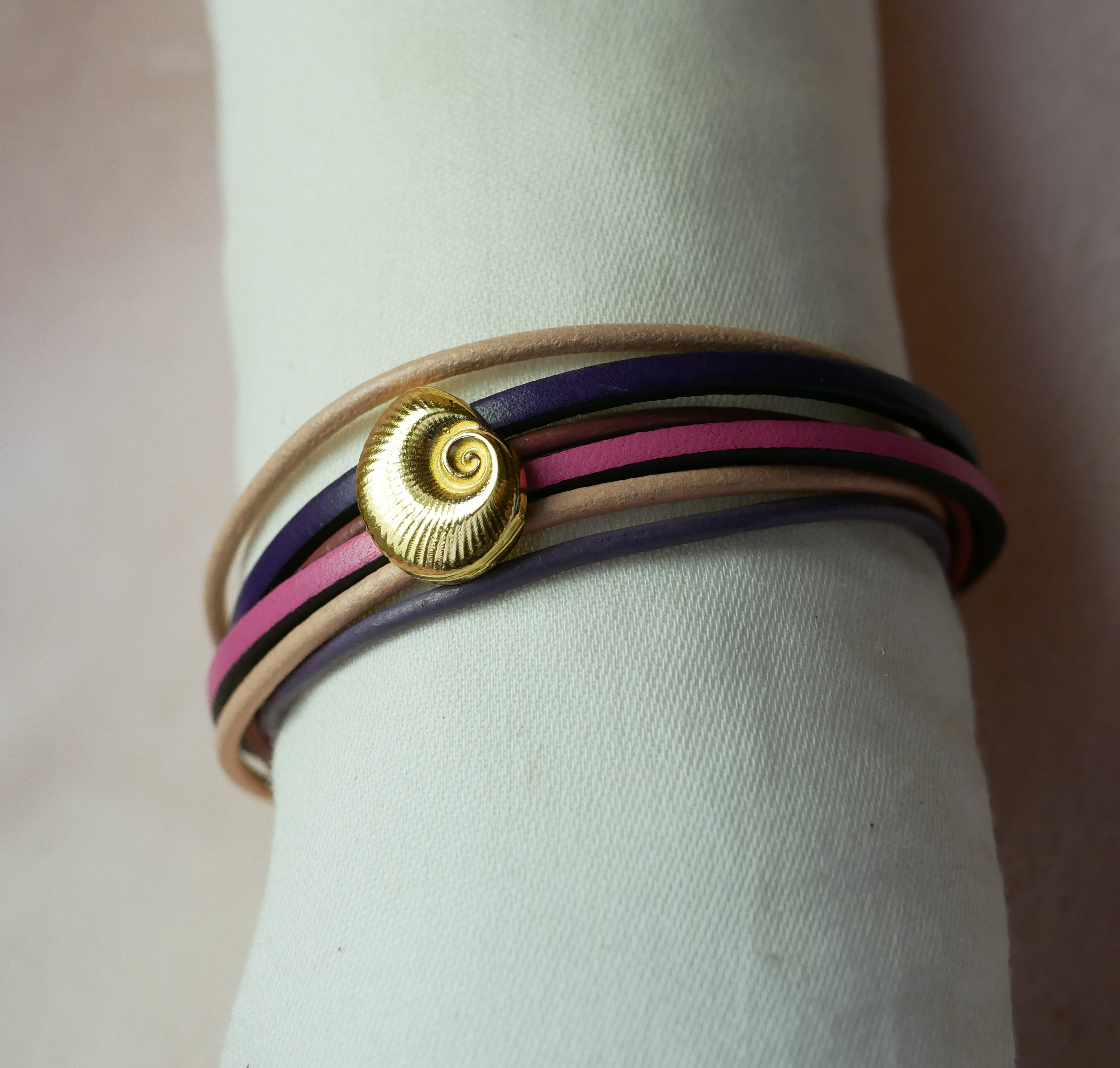 Armband med flera länkar i persika- och mauvefärgat läder med dekor av guldskal