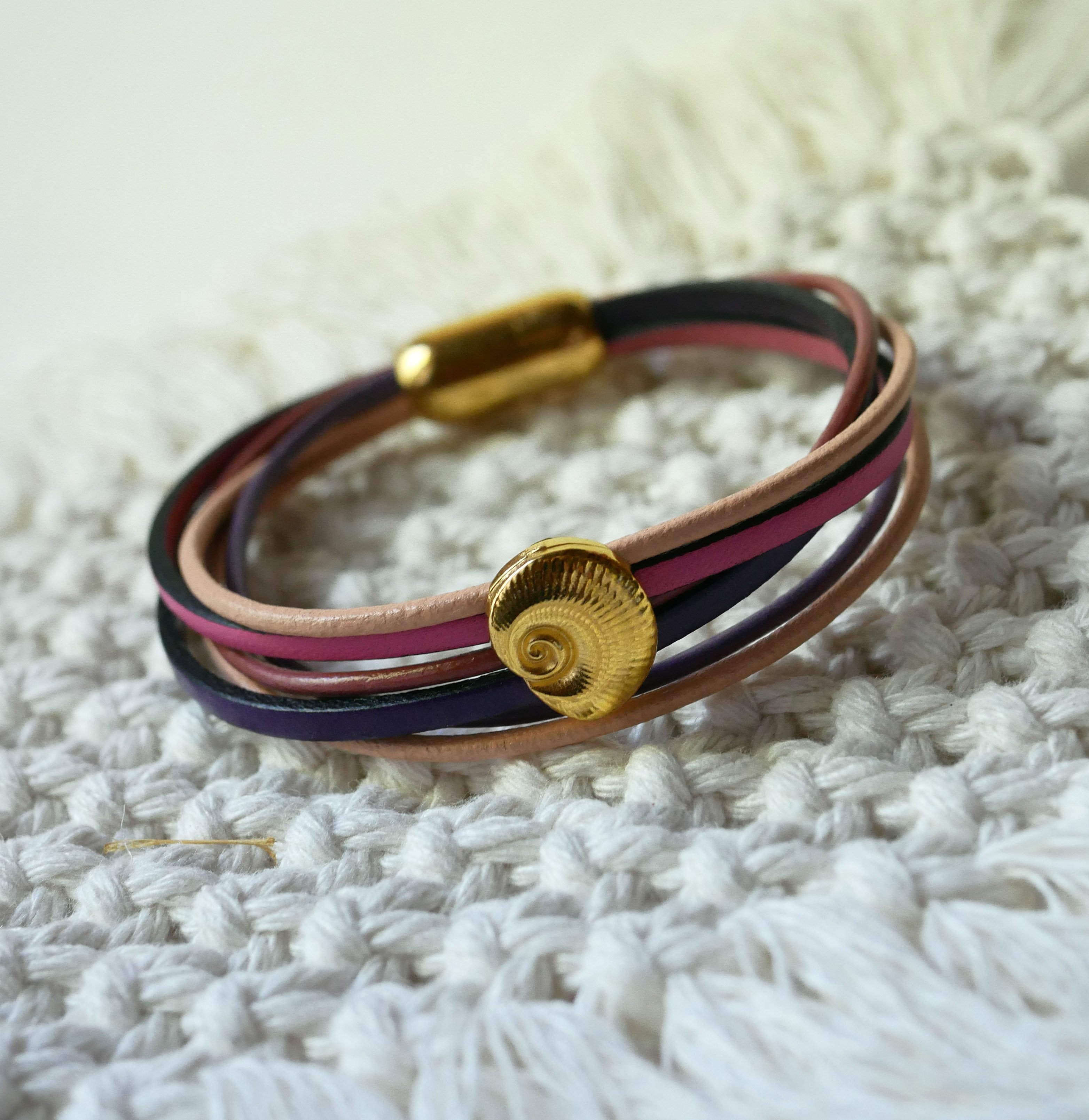 Armband med flera länkar i persika- och mauvefärgat läder med dekor av guldskal