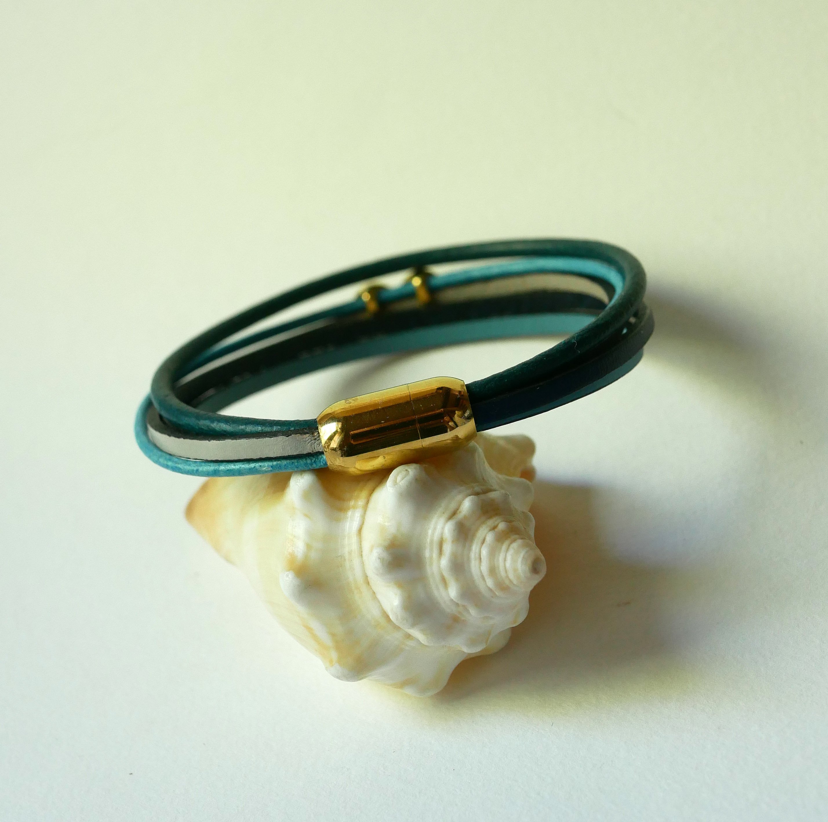 Flerlänkat armband i blåtonat läder med infinitymotiv i guld