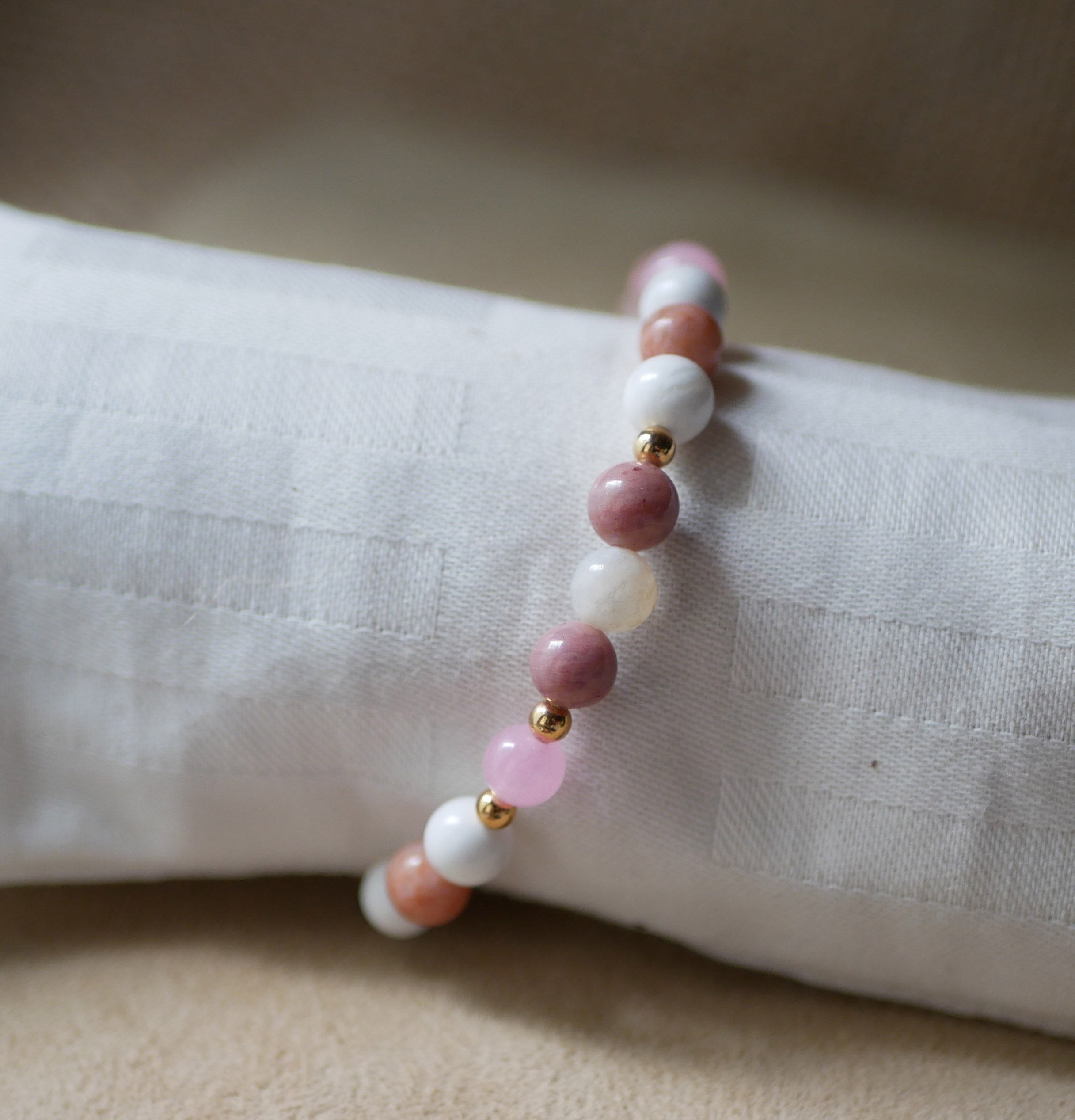 Armband med naturstenarna howlit och rhodonit samt guldpärlor