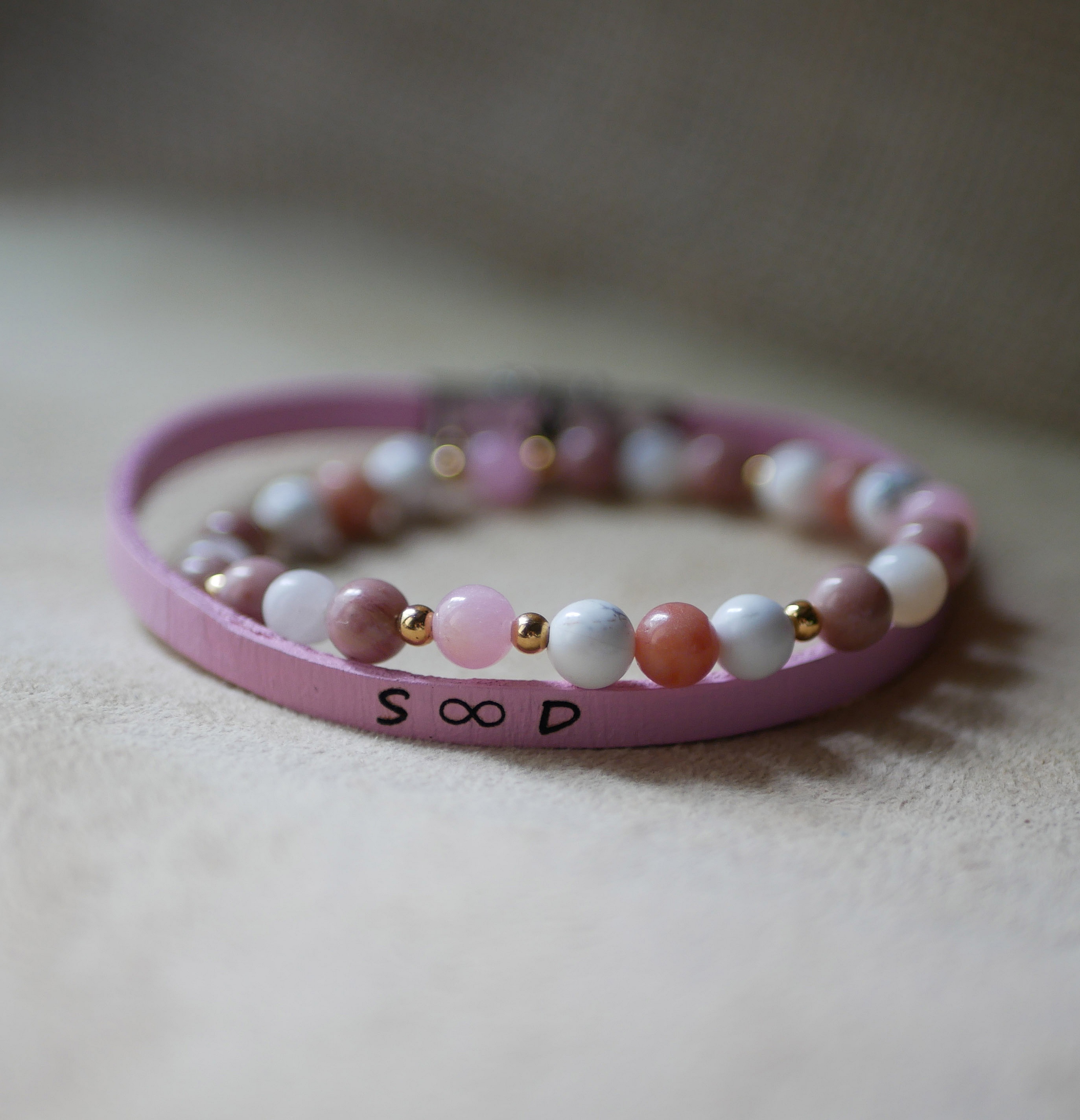 Armband med naturstenarna howlit och rhodonit samt guldp&auml;rlor