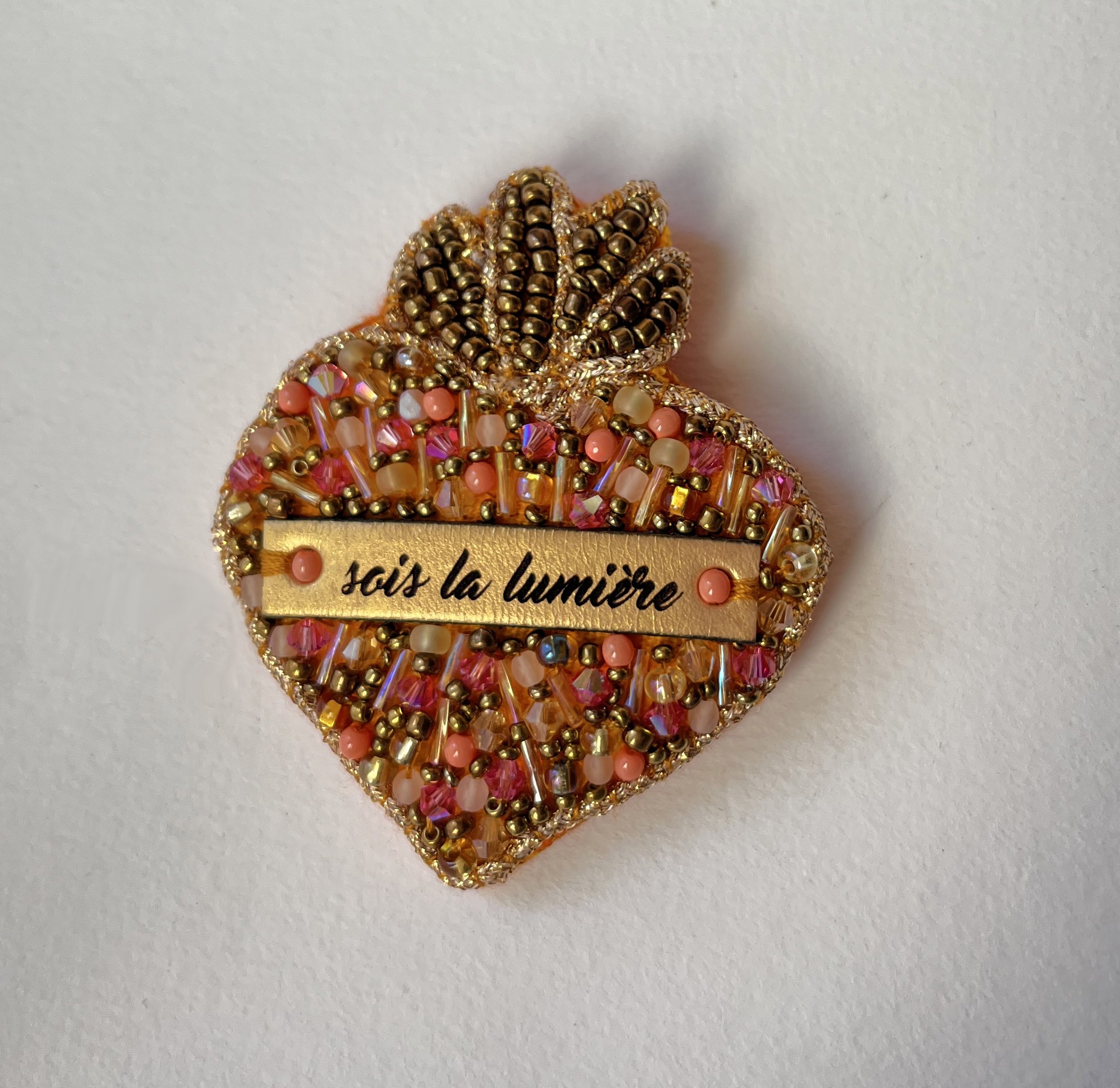 Broche ex-voto Sacré Coeur en perles roses au message gravé Sois la lumière