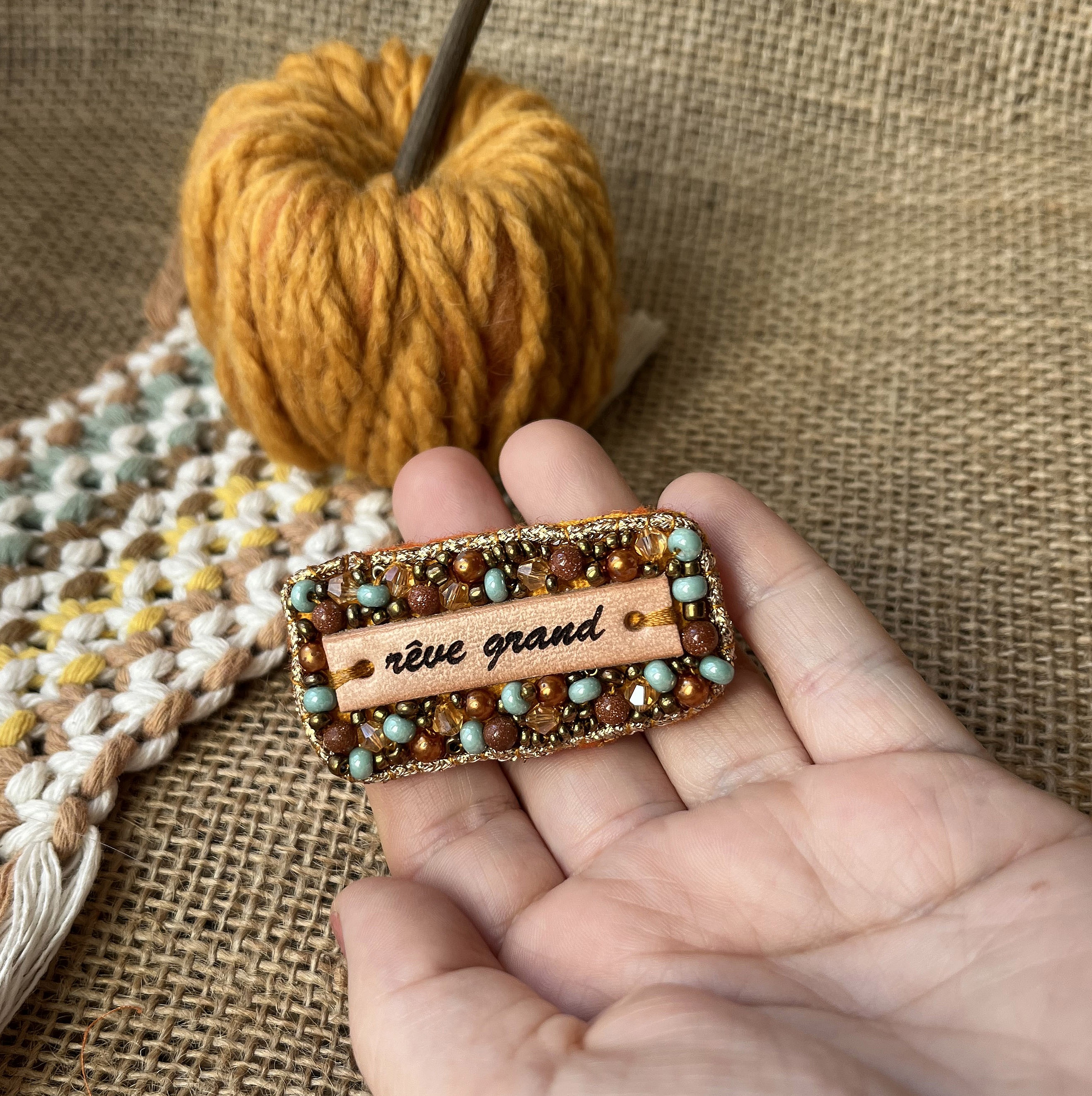 Broche en perles dor&eacute;es &agrave; message en cuir grav&eacute; "r&ecirc;ve grand"