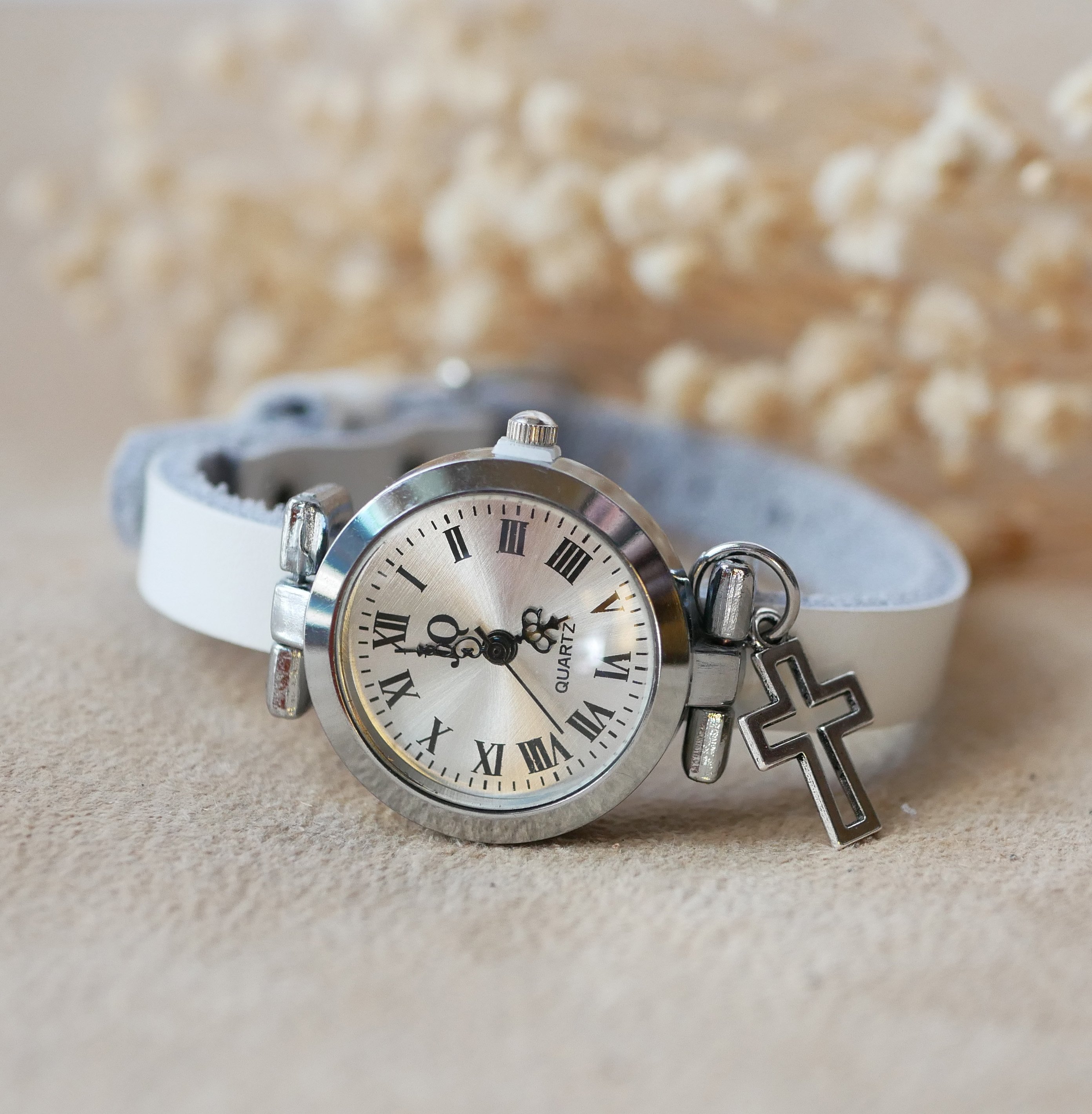Silverfärgad klocka med läderarmband och silverfärgat spänne