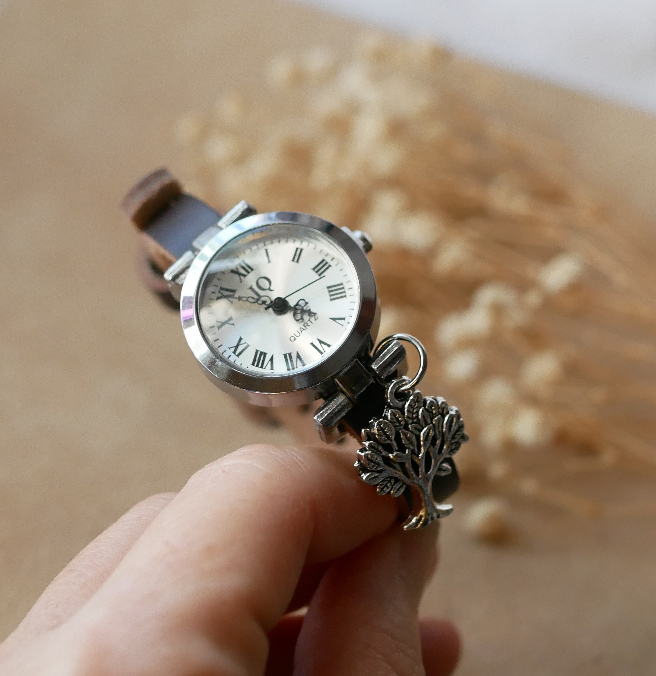Silverfärgad klocka med läderarmband och silverfärgat spänne