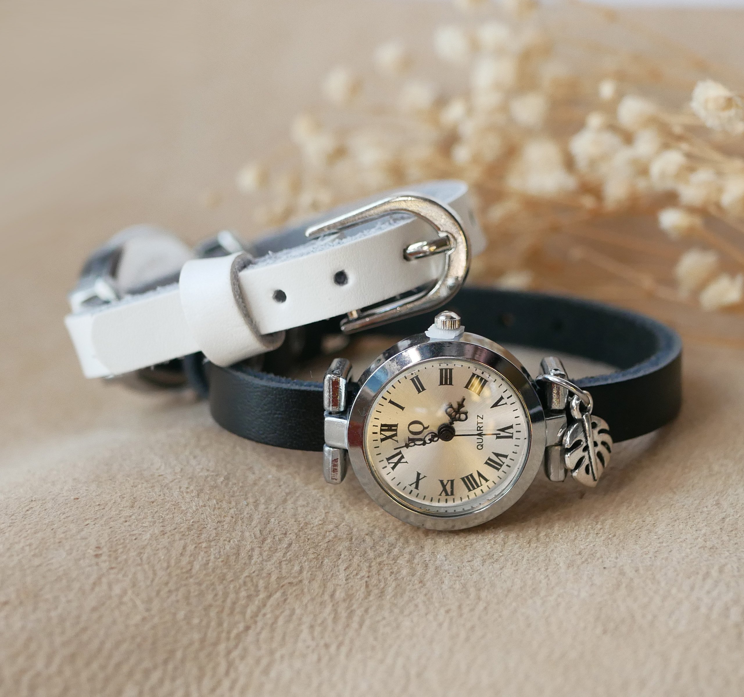 Silverfärgad klocka med läderarmband och silverfärgat spänne