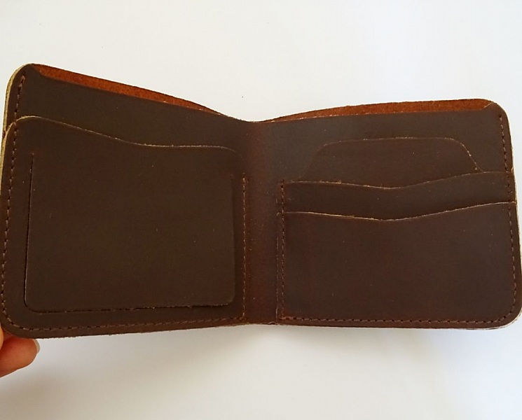 Porte-cartes artisanal en cuir marron avec compartiments intérieurs.