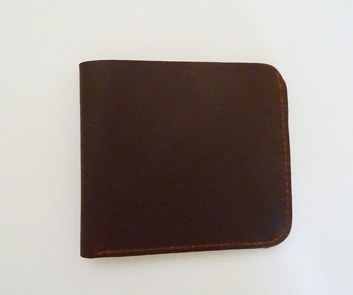 Porte-cartes artisanal en cuir marron épais et compact.