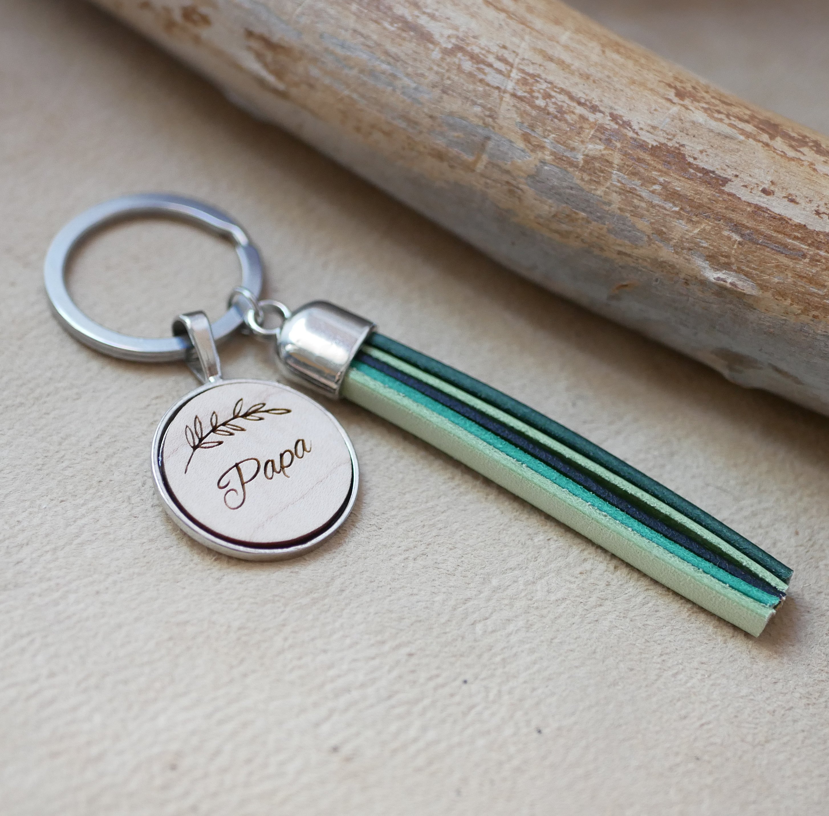 Specialtillverkad nyckelring i läder och trä med läderpompom och graverad cabochon