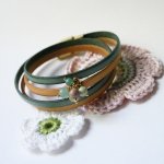Dubbelt läderarmband dekorerat med mjuka gröna pärlor och guldspänne