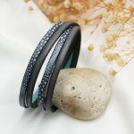 Blått läderarmband med ormmönster att personifiera
