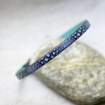 Kvinnoarmband i fint läder med ormtryck i blå toner