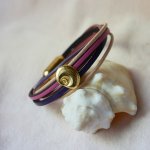 Armband med flera länkar i persika- och mauvefärgat läder med dekor av guldskal